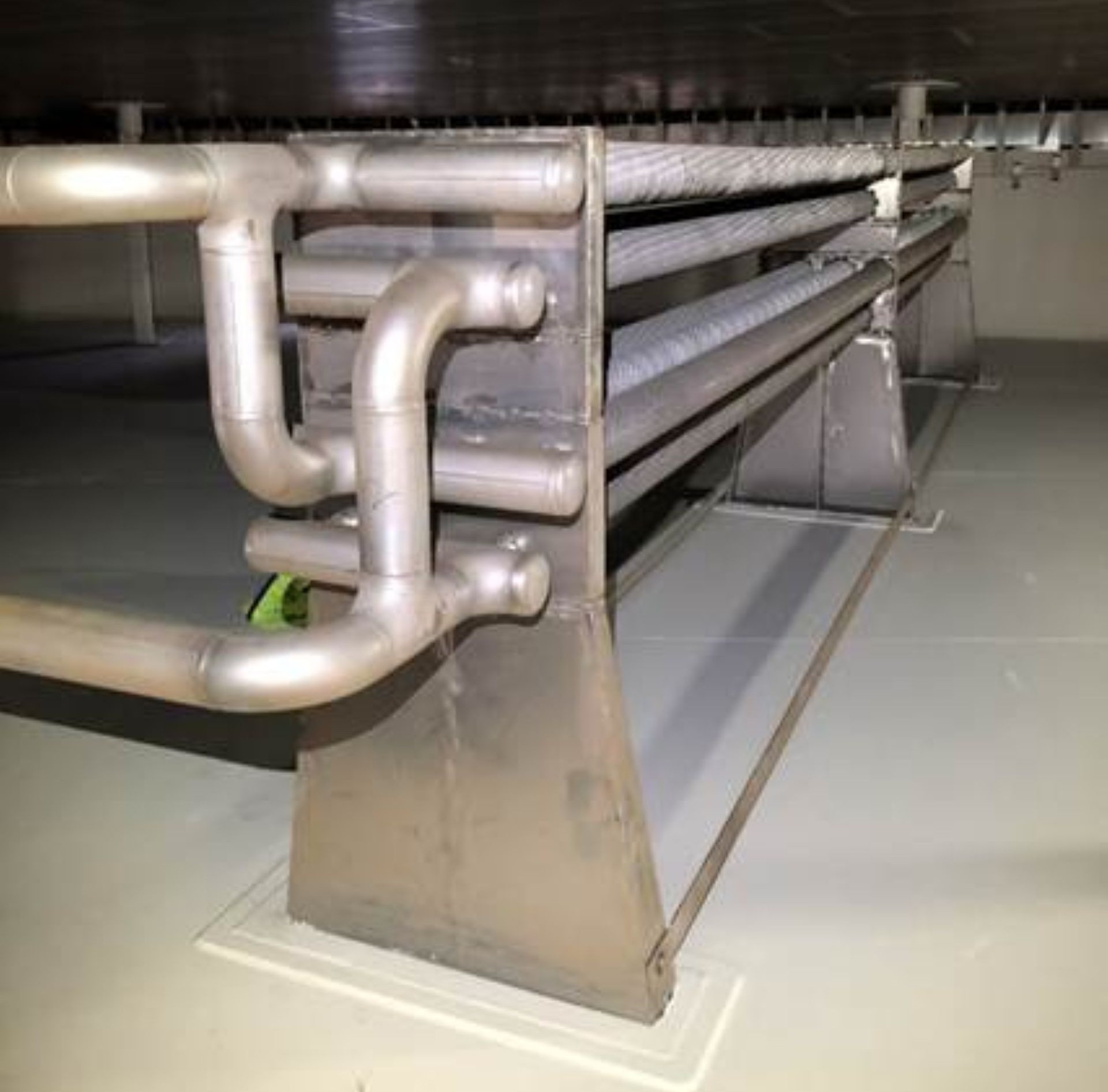 Close up of pipework inside a large metal container, running from bottom left of pic to top right