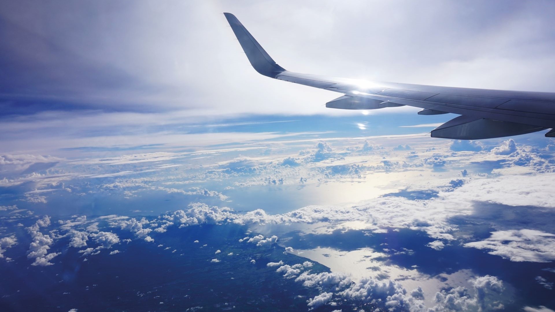 aircraft wing flying above clouds