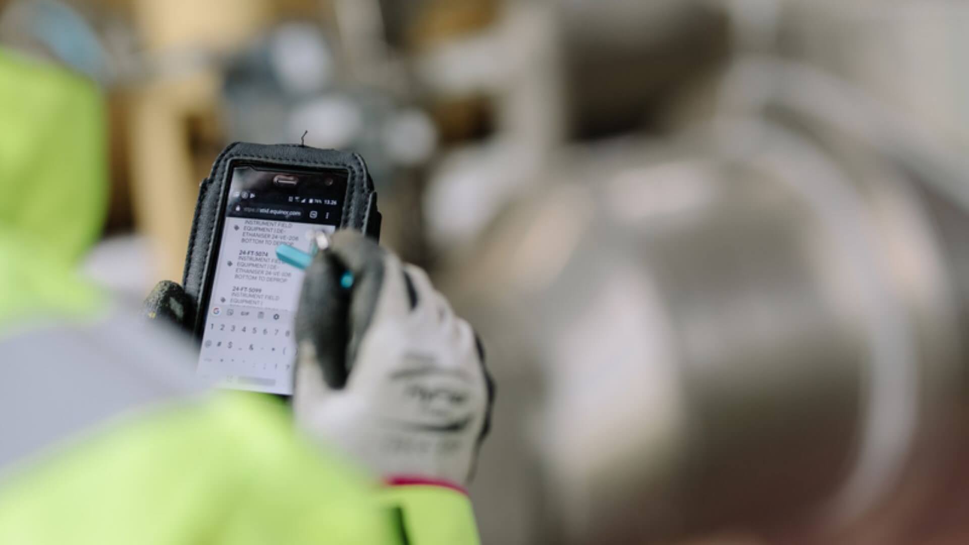 close up of industry worker's hand using a smart mobile tech device