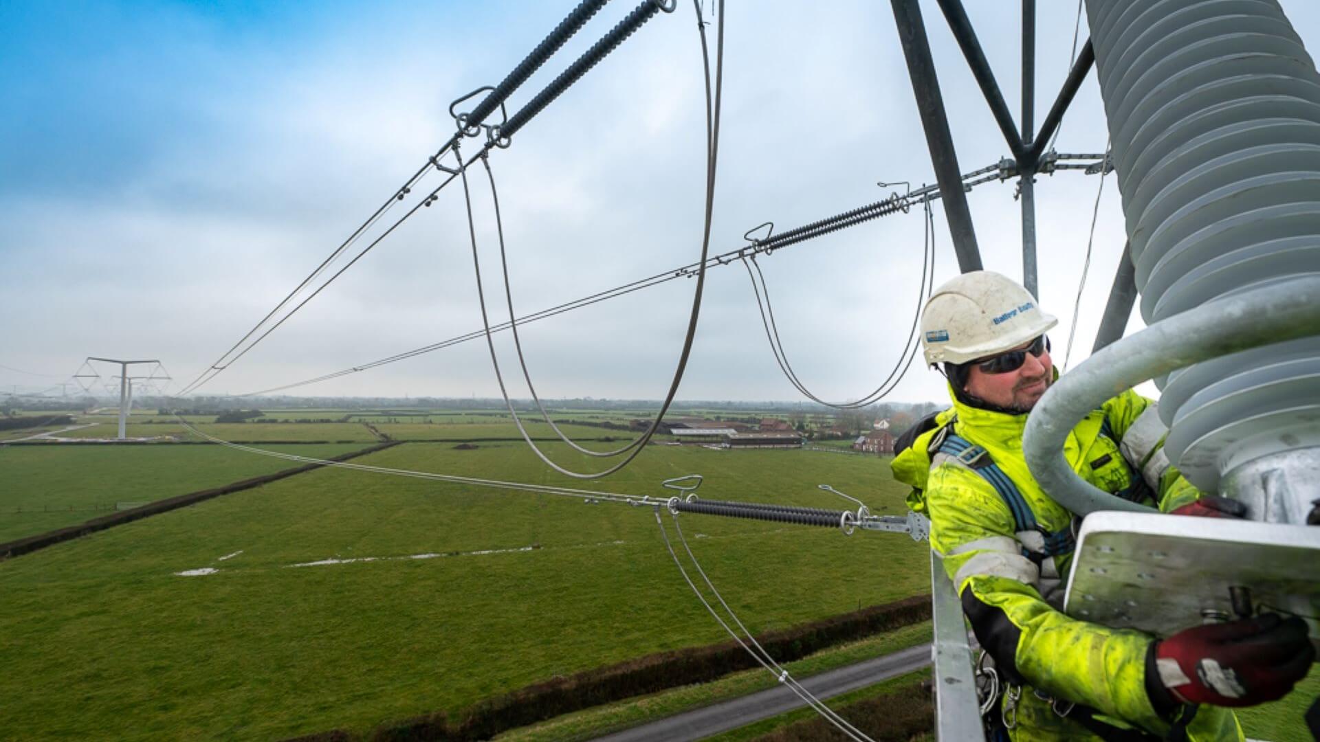 Engineer stringing conductors from new T-pylon to carry electricity from Hinkley Point C
