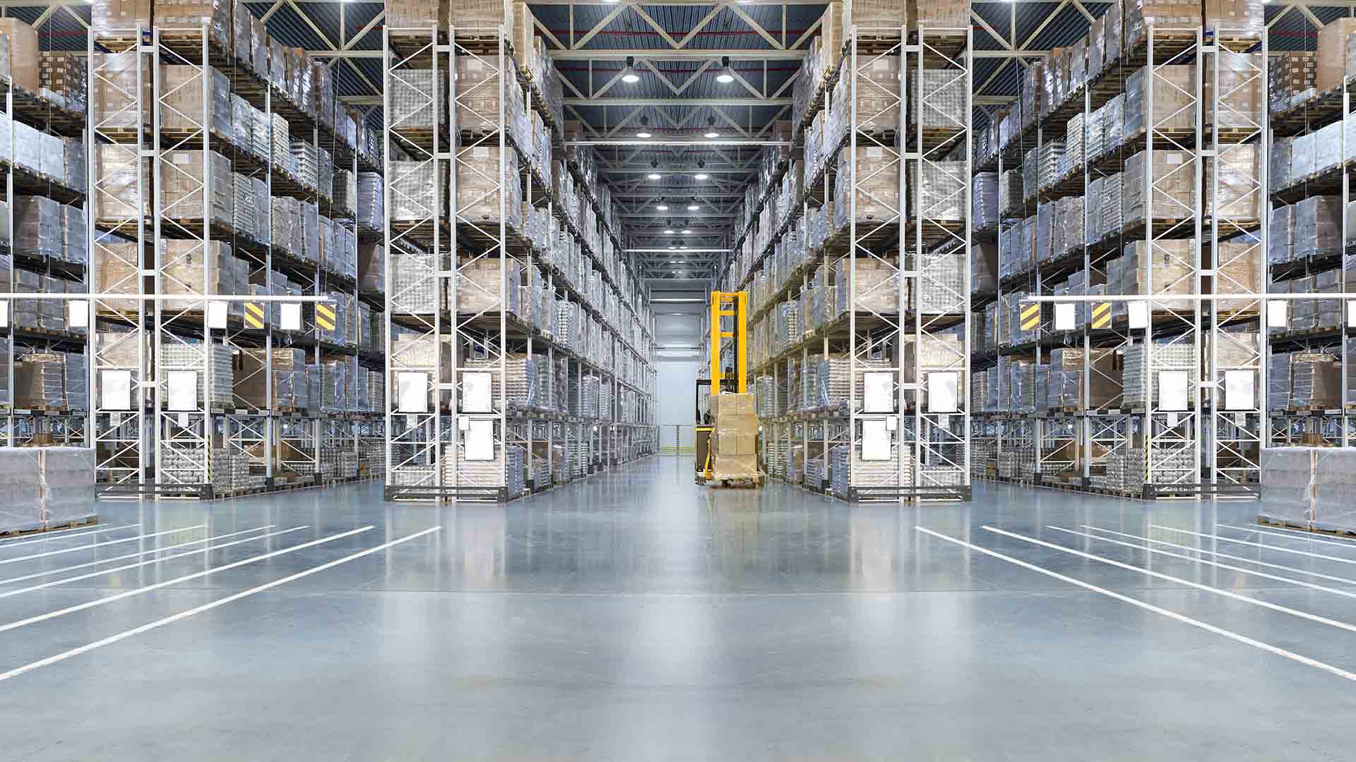 Large warehouse storage with stacked shelves and forklift truck