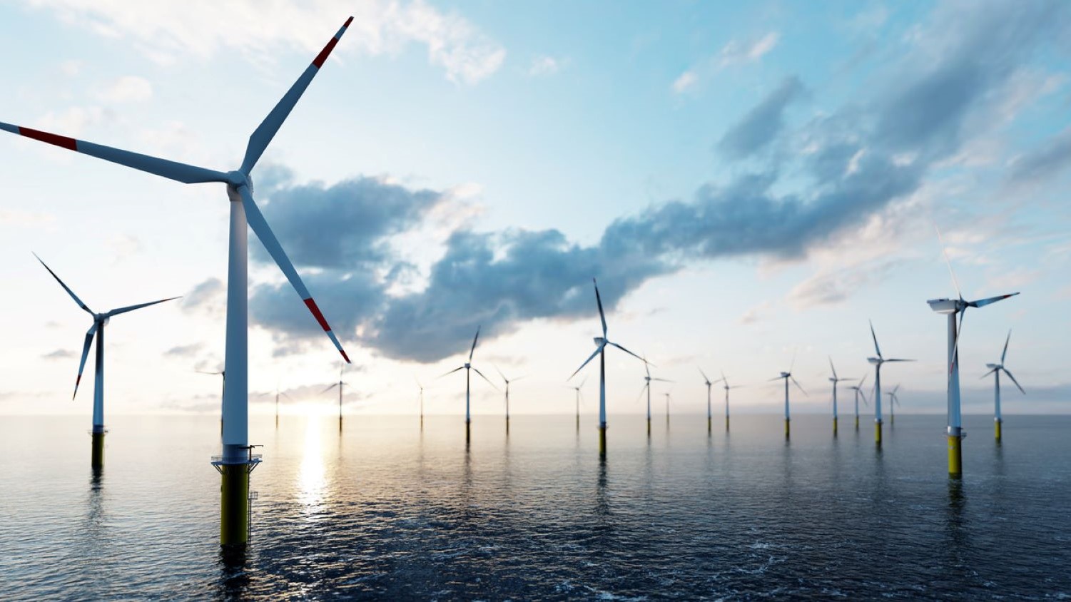 Offshore wind farm set against cloudy blue sky