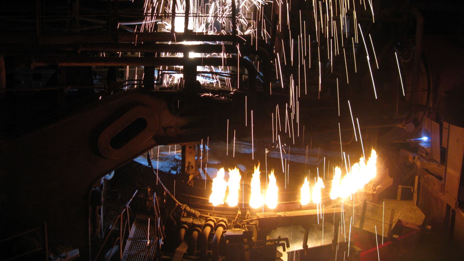Orange sparks flying out from an electric arc furnace