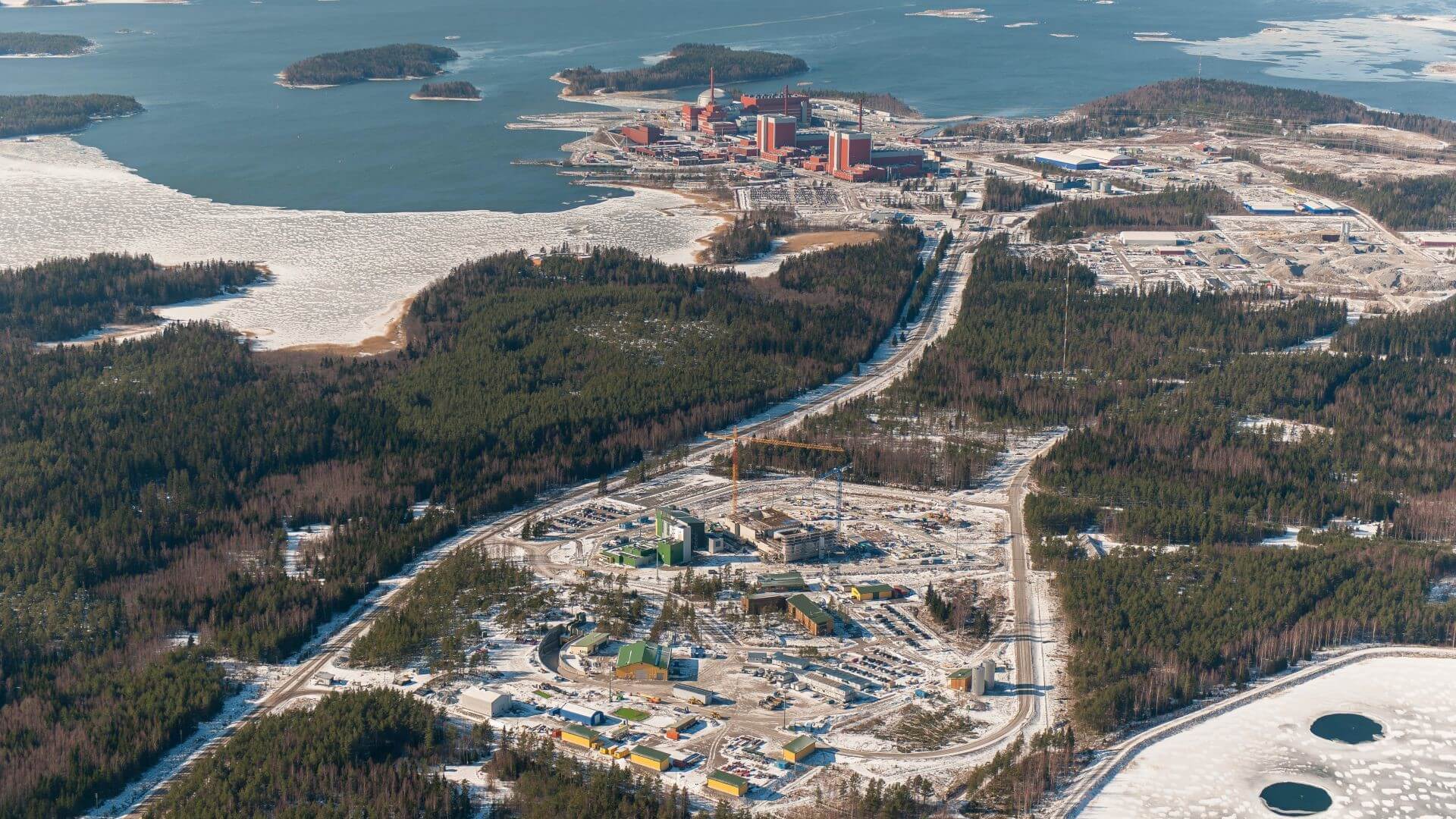 Aerial view over Finland's Olkiluoto nuclear power station's three nuclear reactors and Posiva's Onkalo nuclear waste repository 