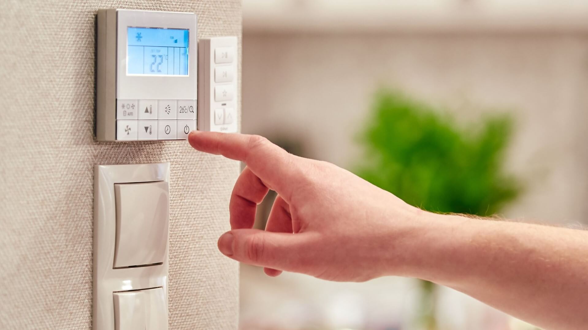 Person adjusting the temperature on a thermostat