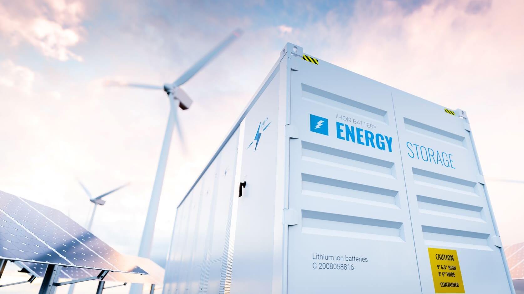 White energy storage container with solar panels to the left and wind turbines between 