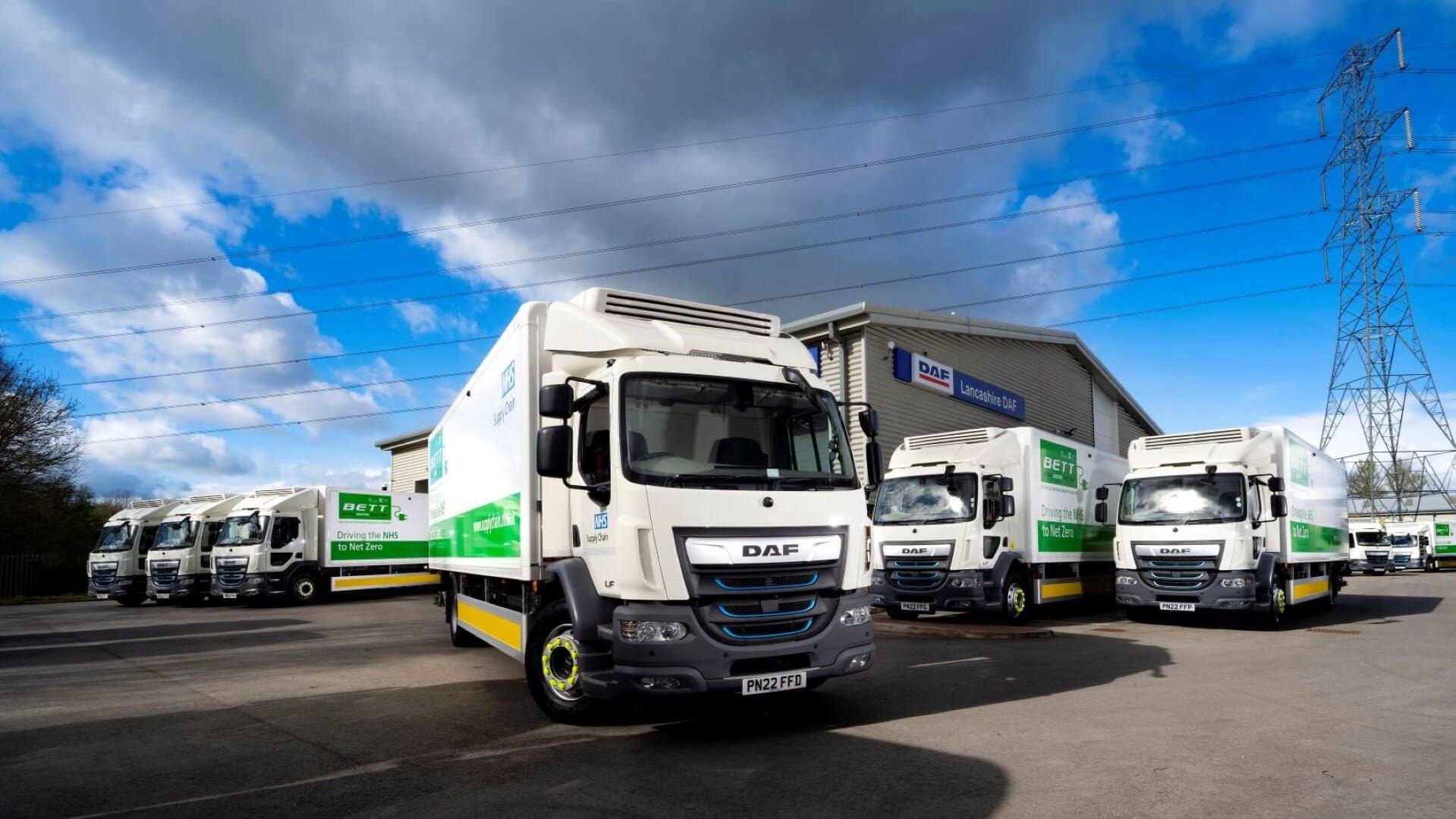 Electric DAF lorries with a warehouse behind