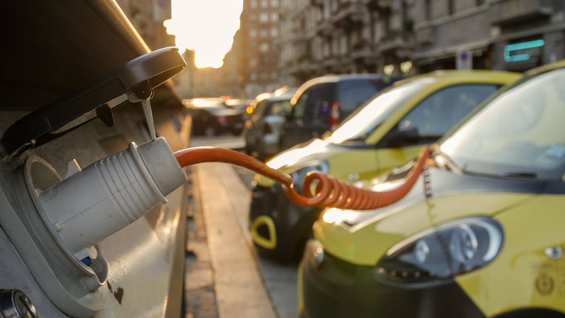 EV charger and row of cars in street