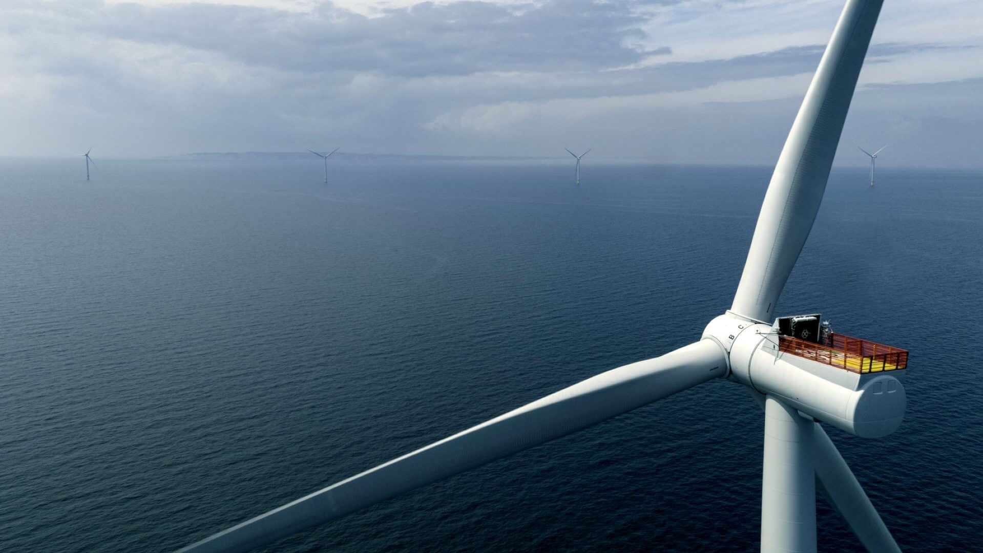 Close up of offshore wind turbine blade with sea behind