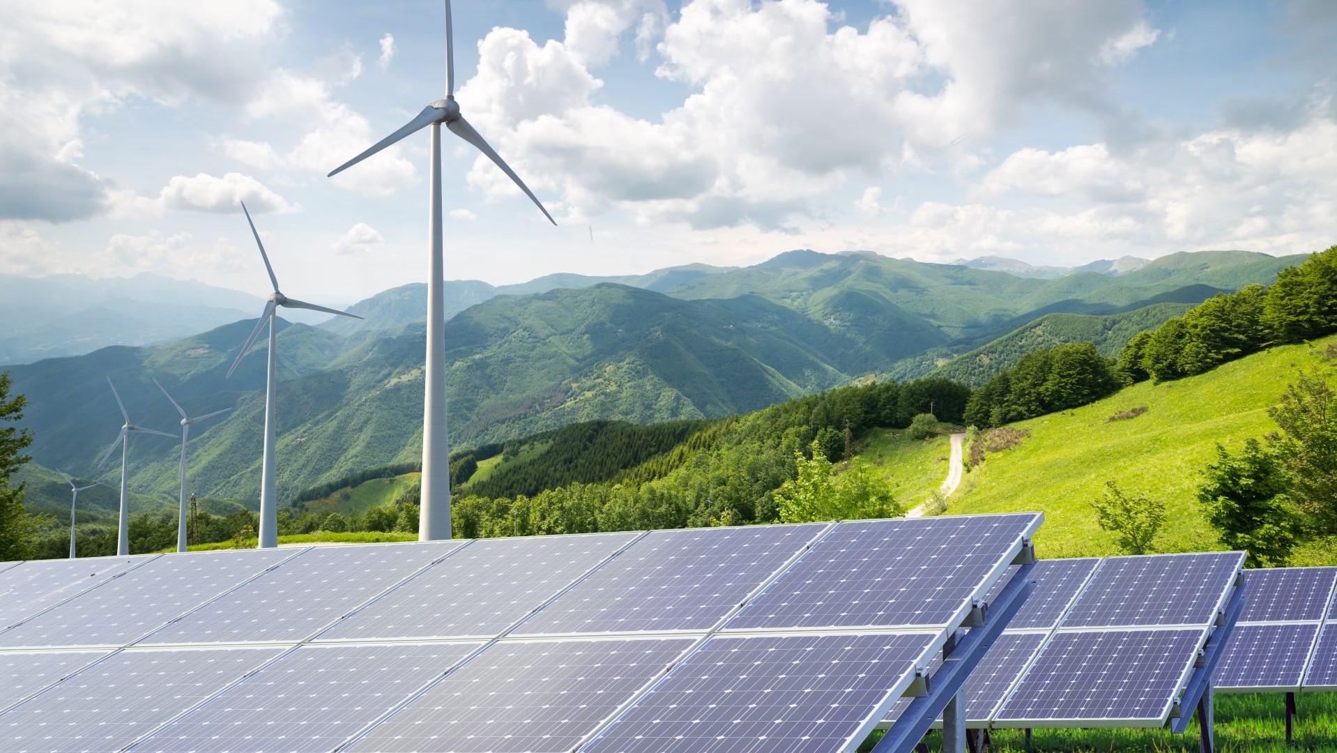 Wind turbine and solar panel near mountains 