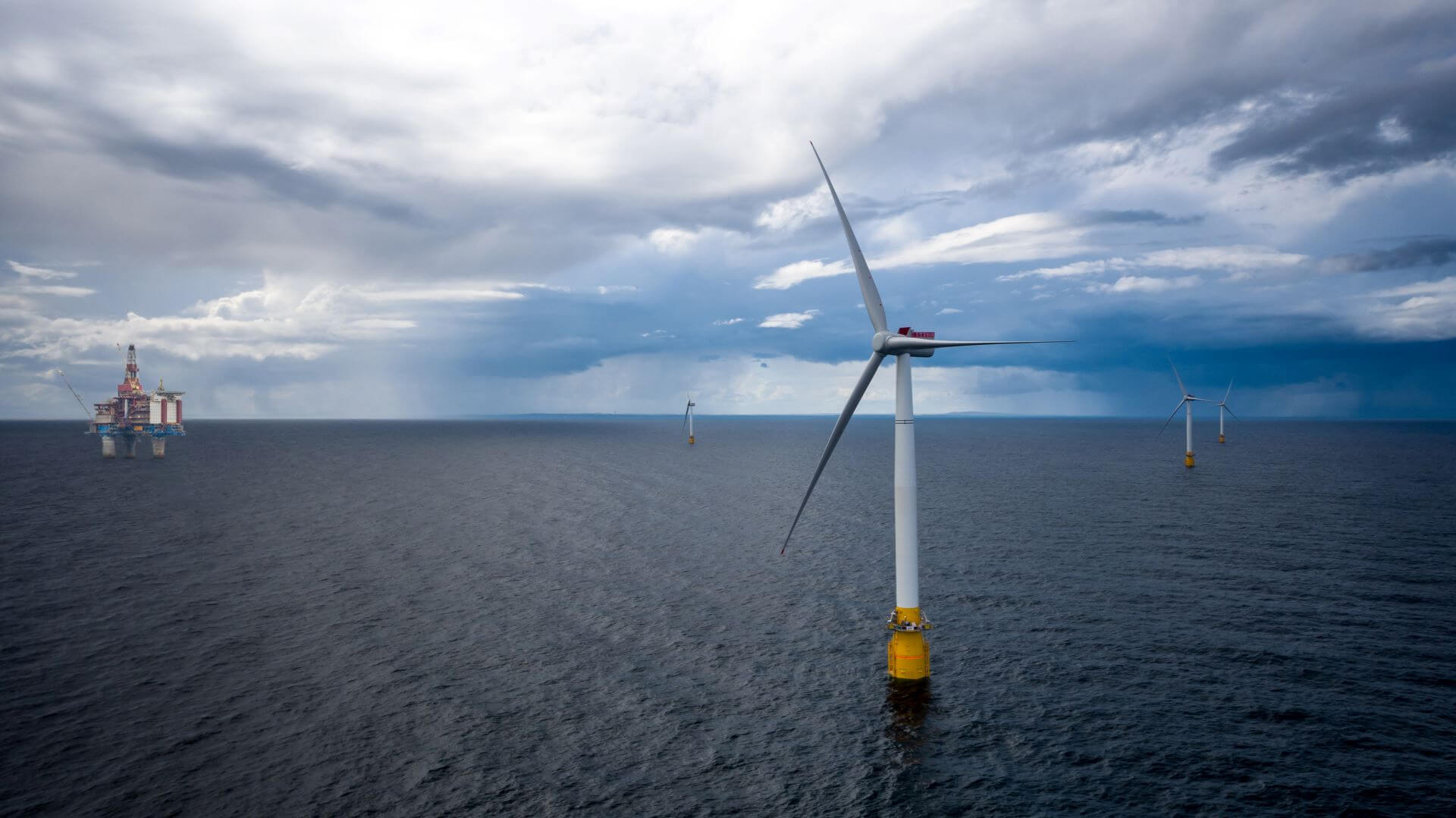 Hywind Tamplen floating wind farm with turbine in foreground and Gullfaks platform in background