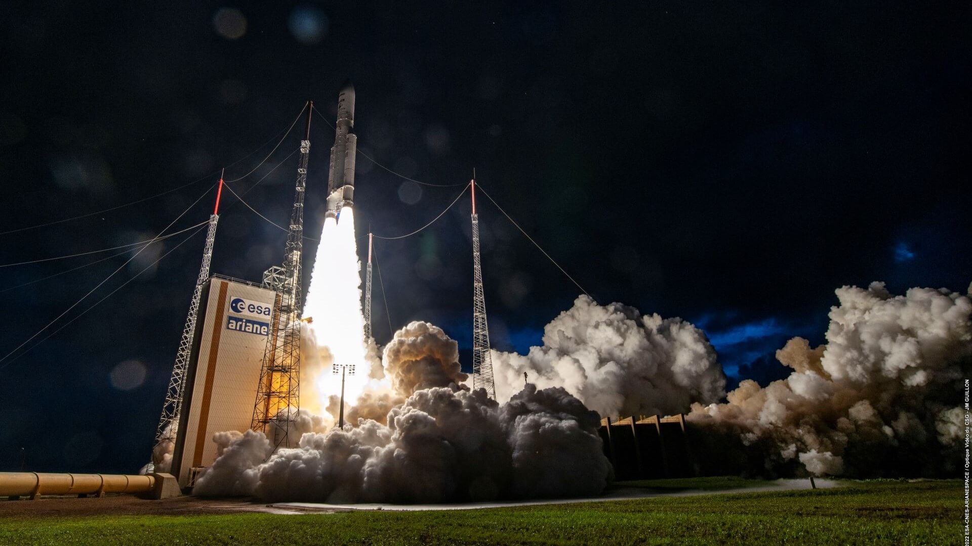 Space rocket launch at night, with bright flames and billowing smoke