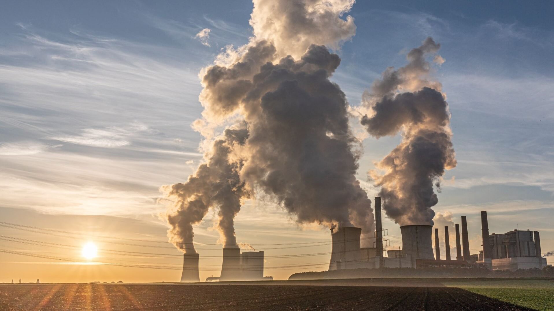 View of Neurath coal-fired power plant, Germany with large clouds of smoke coming from chimneys