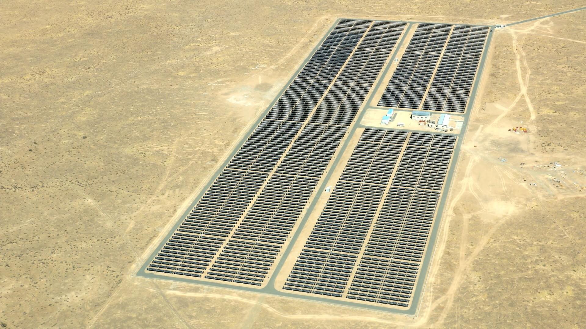 Aerialview of African solar farm's solar panels surrounded by desert sand