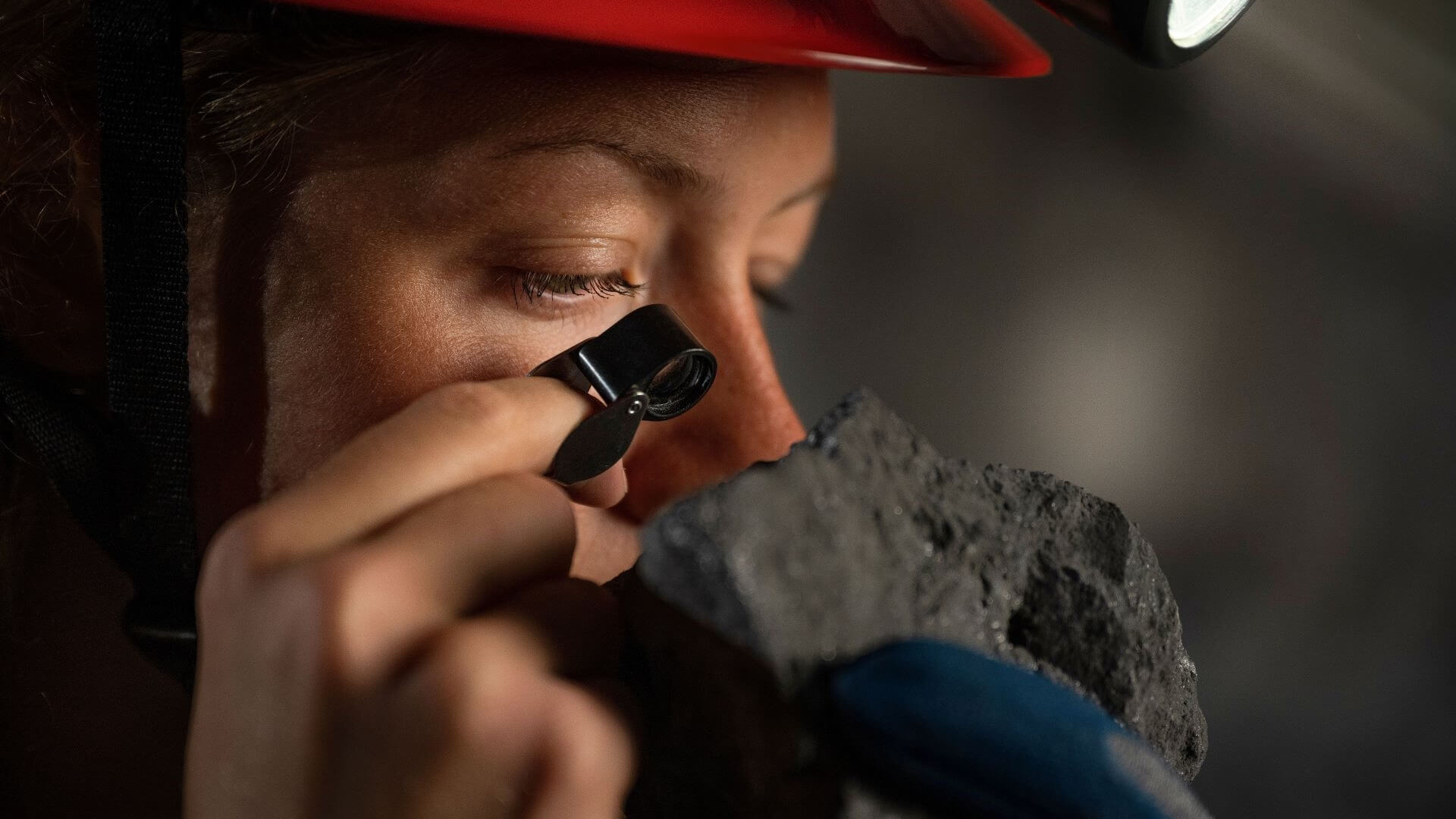 Scientist using magnifier to study rare earth oxides