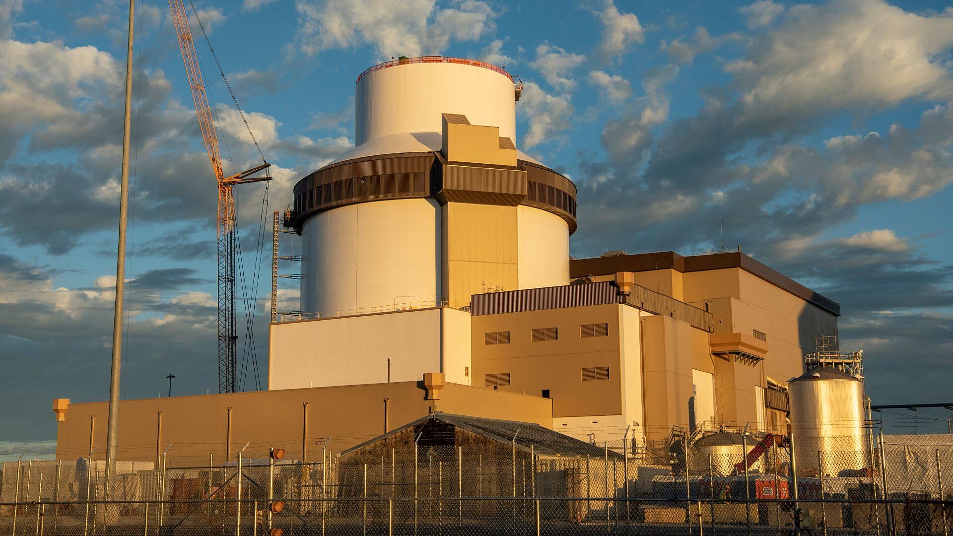 Nuclear power plant buildings set against blue sky and white fluffy clouds