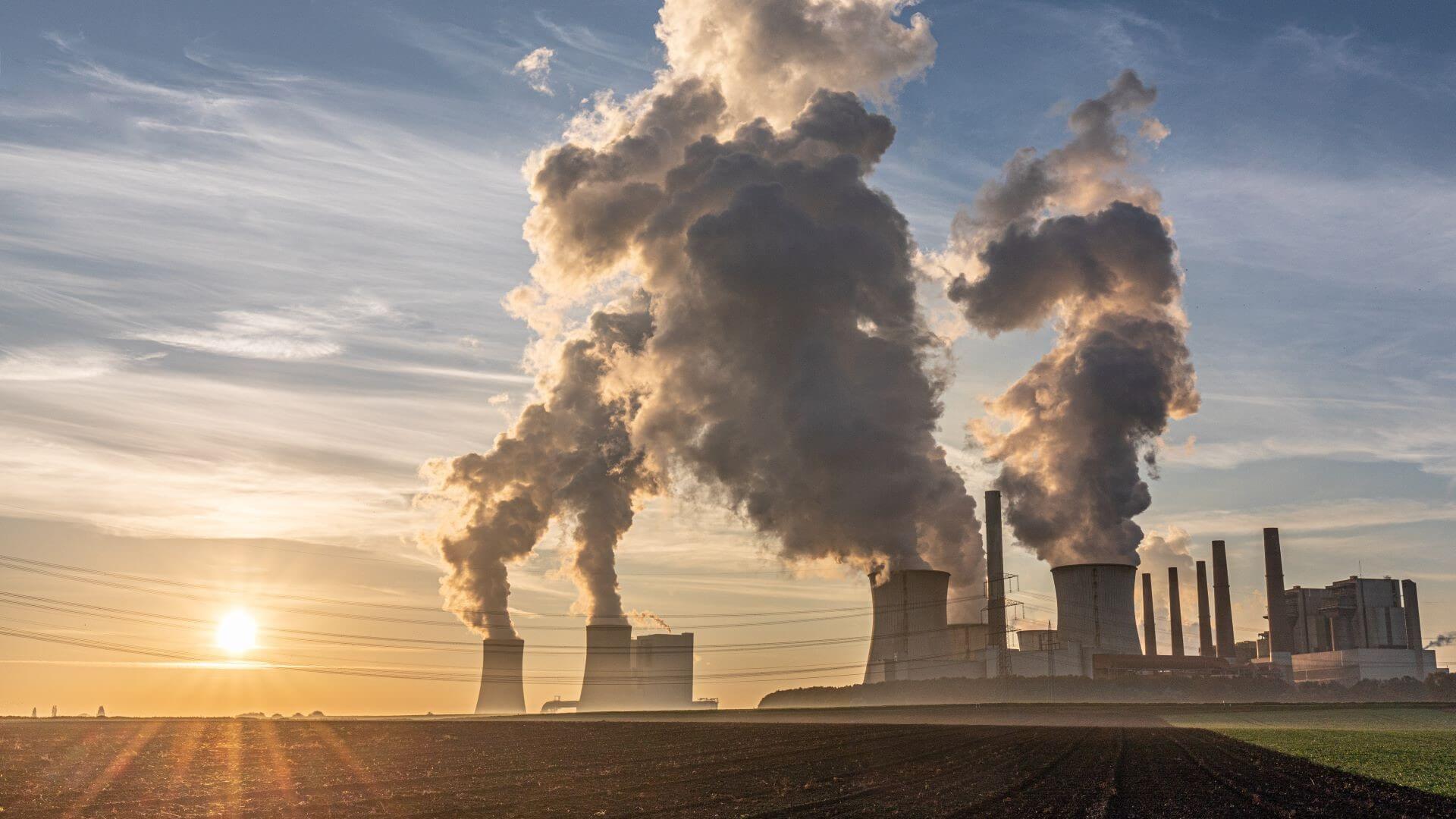 View of chimney emissions at a power plant at sunset