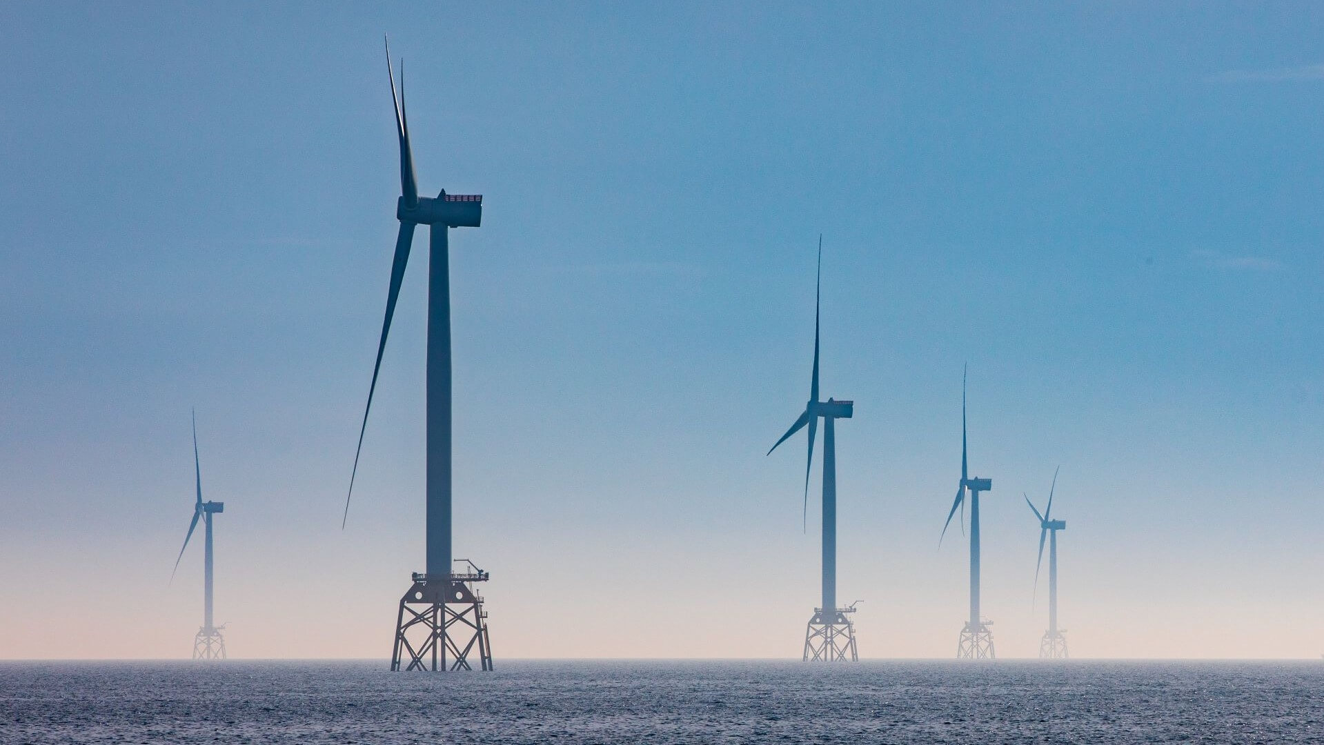 Offshore wind farm in blue sea with blue sky above