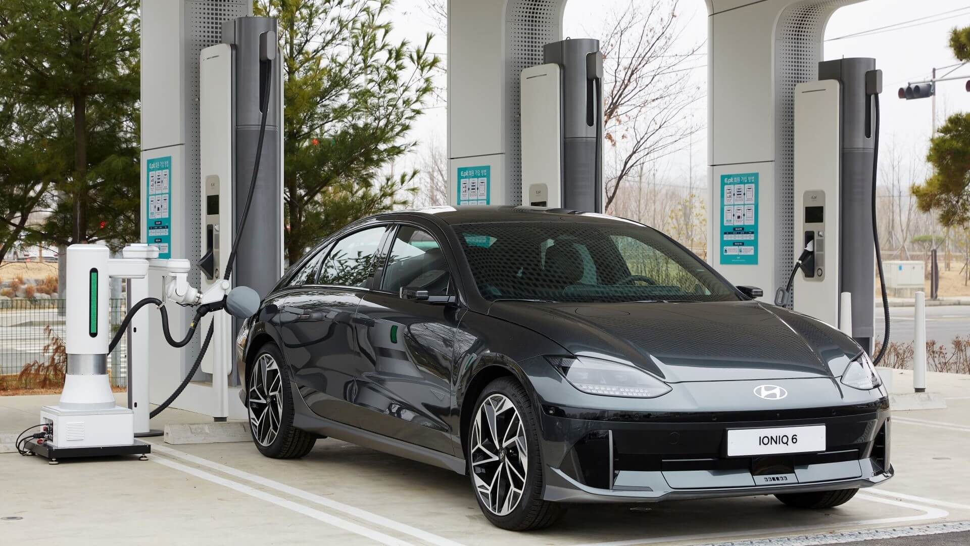 Car at forecourt being refuelled by a robot