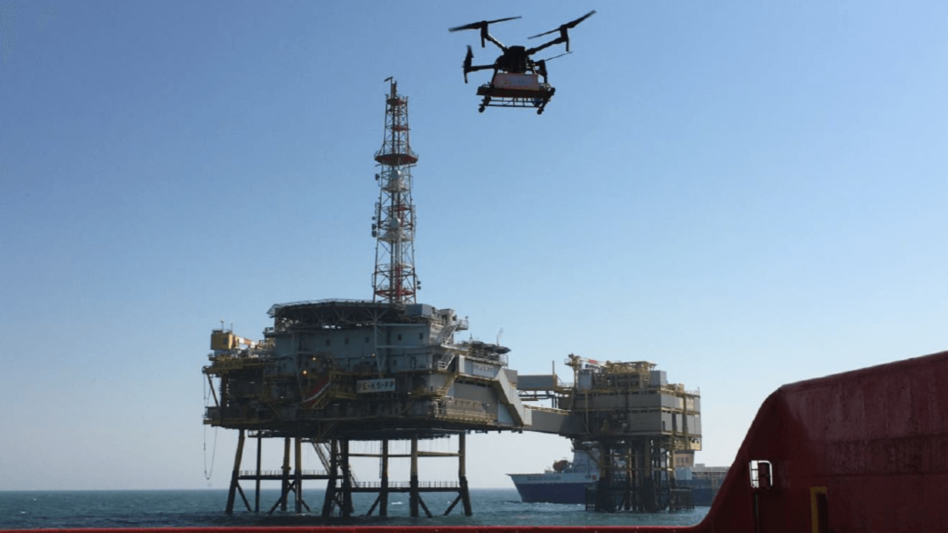 View from vessel of oil and gas platform in distance and methane monitoring drone in air