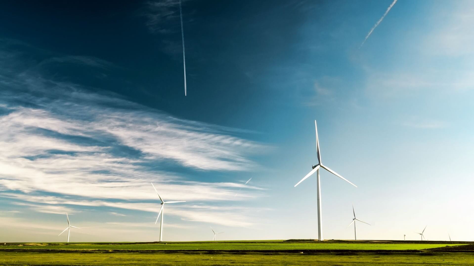Onshore wind turbines in a field with blue sky