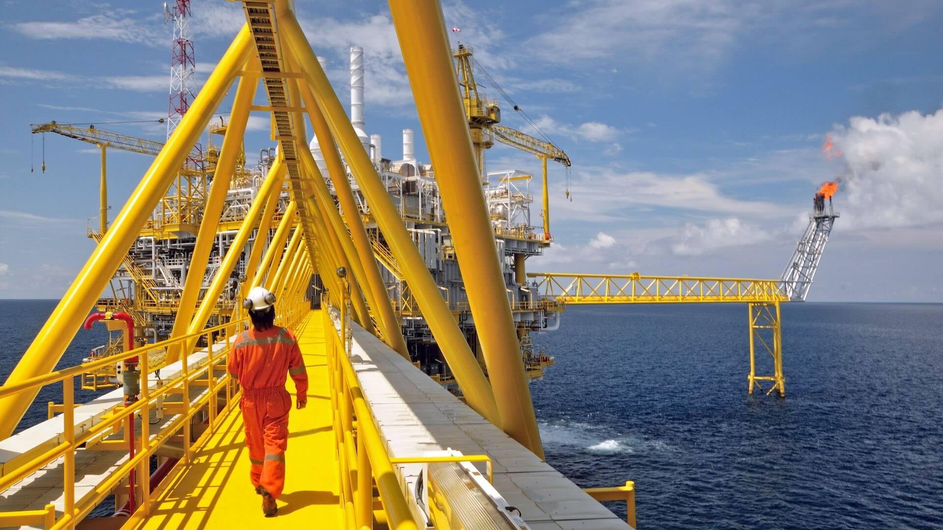 Person walking across bridge on offshore platform