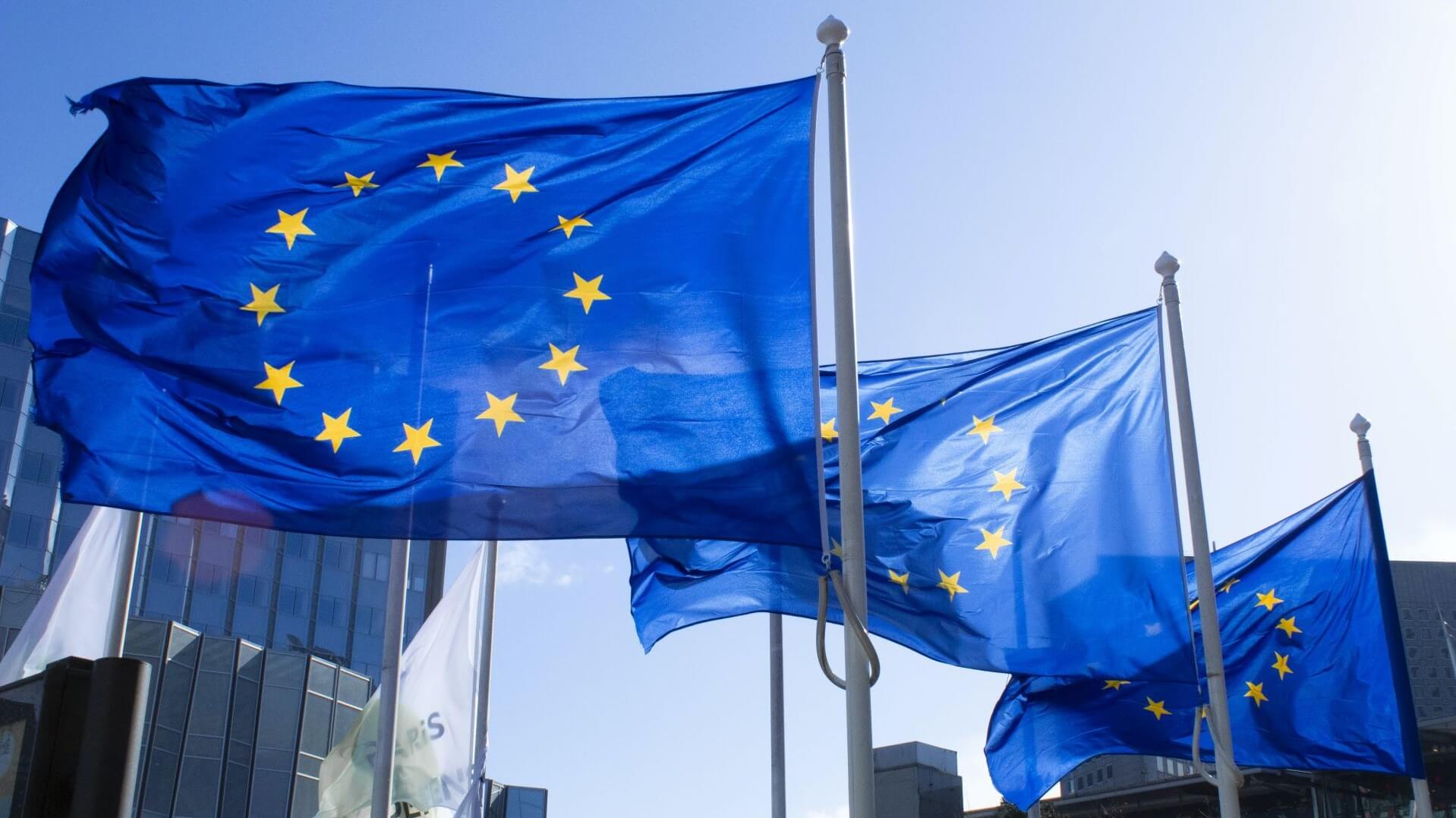 EU flags flying against a bright blue sky