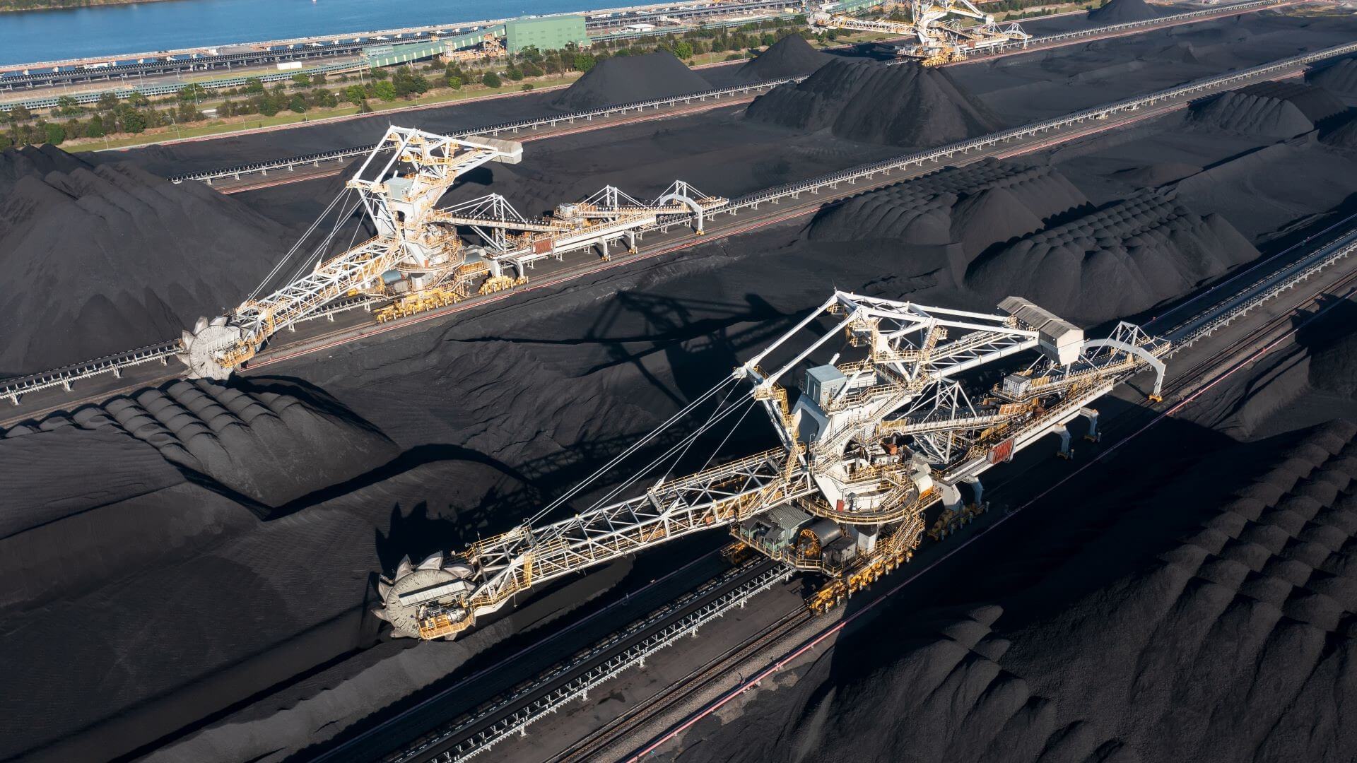 Two huge coal extracting machines working alongside one another on top of open coal mine