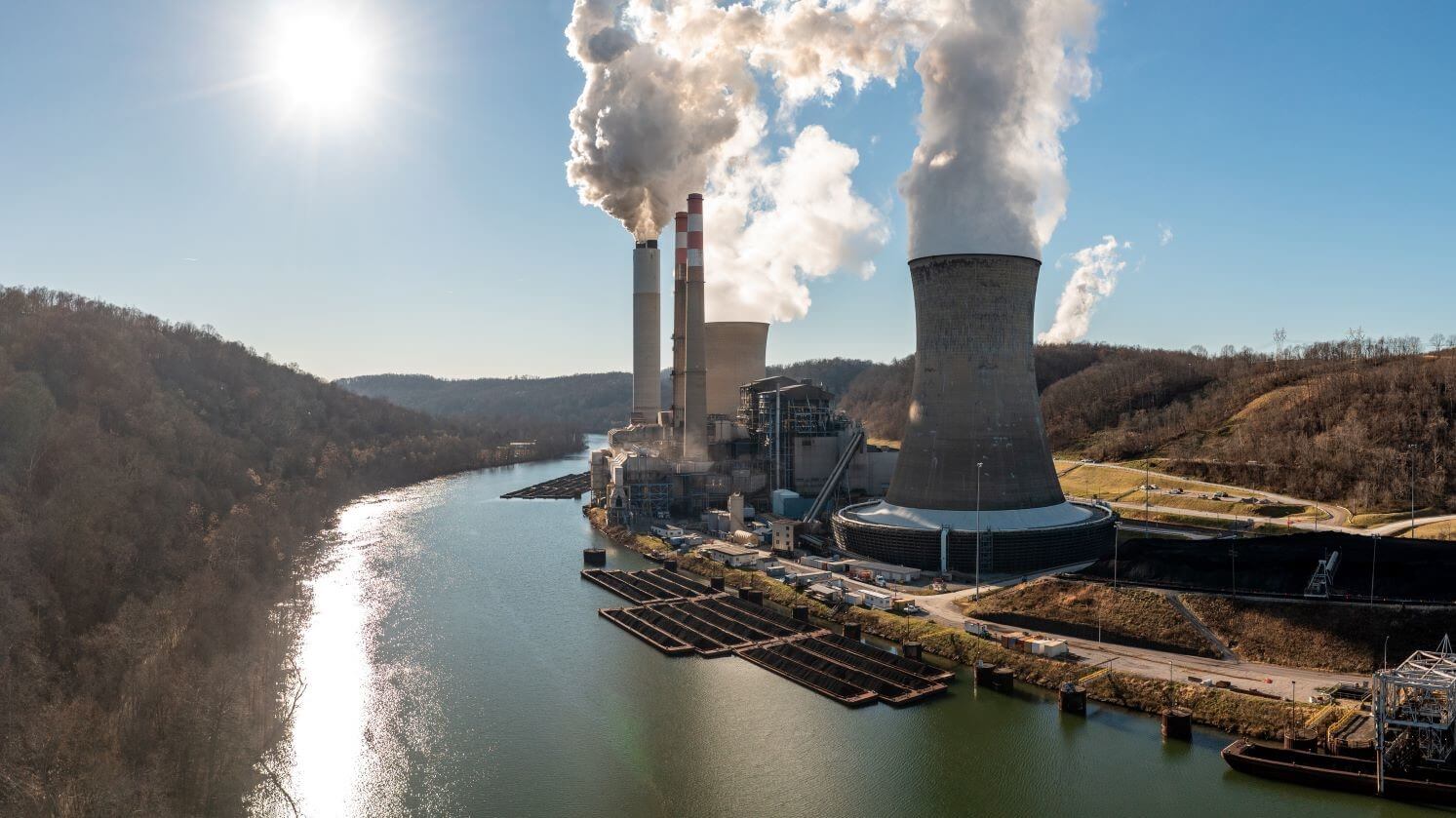 View of US coal-fired power station with emissions beside a river