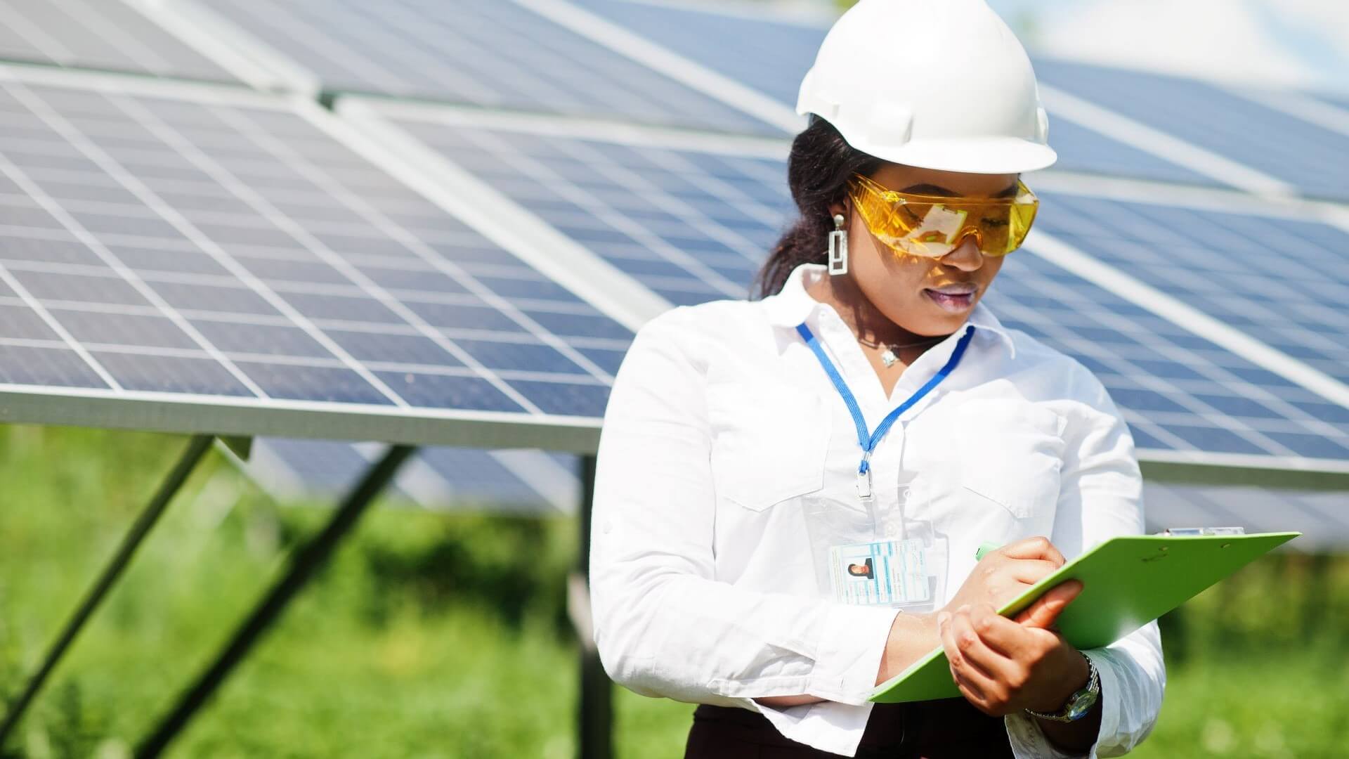 Female engineer with a clipboard at a solar farm