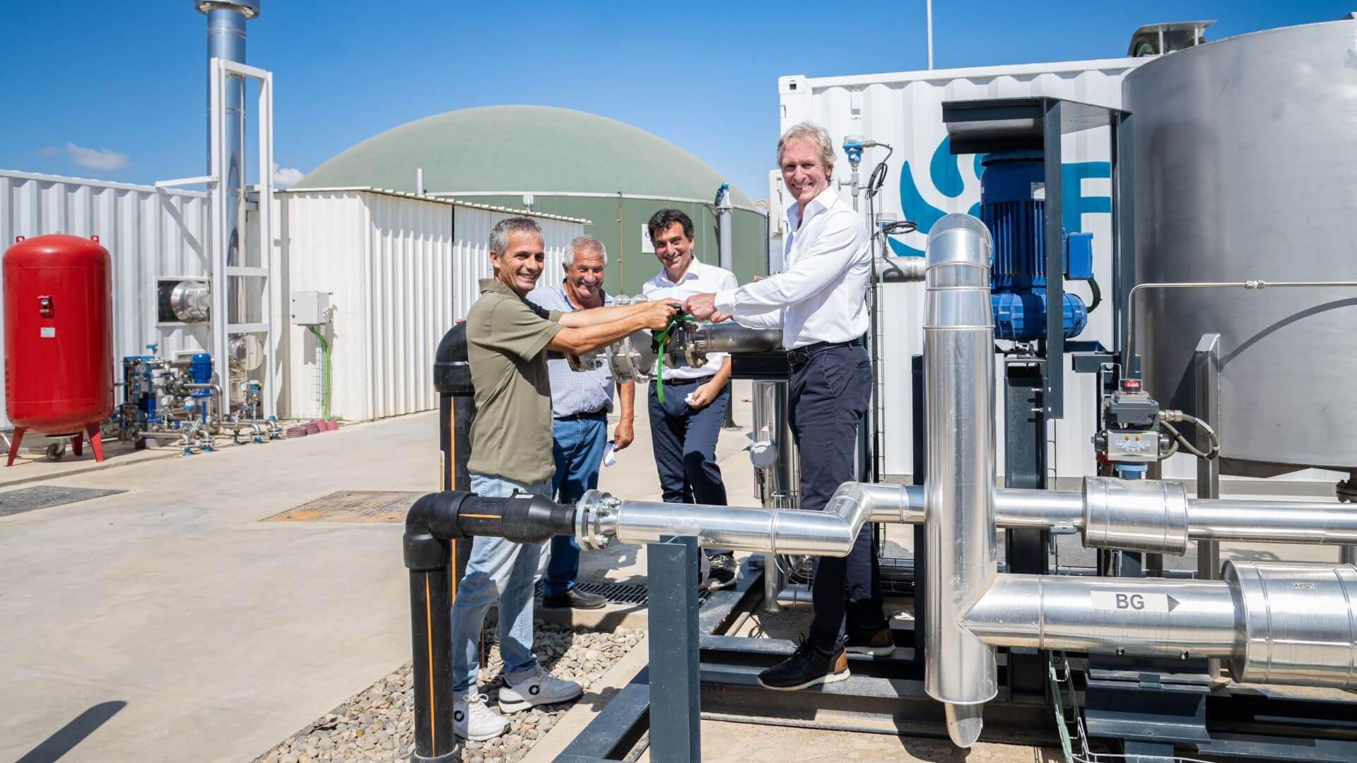 Four men outside biomethane facility during plant's inauguration 
