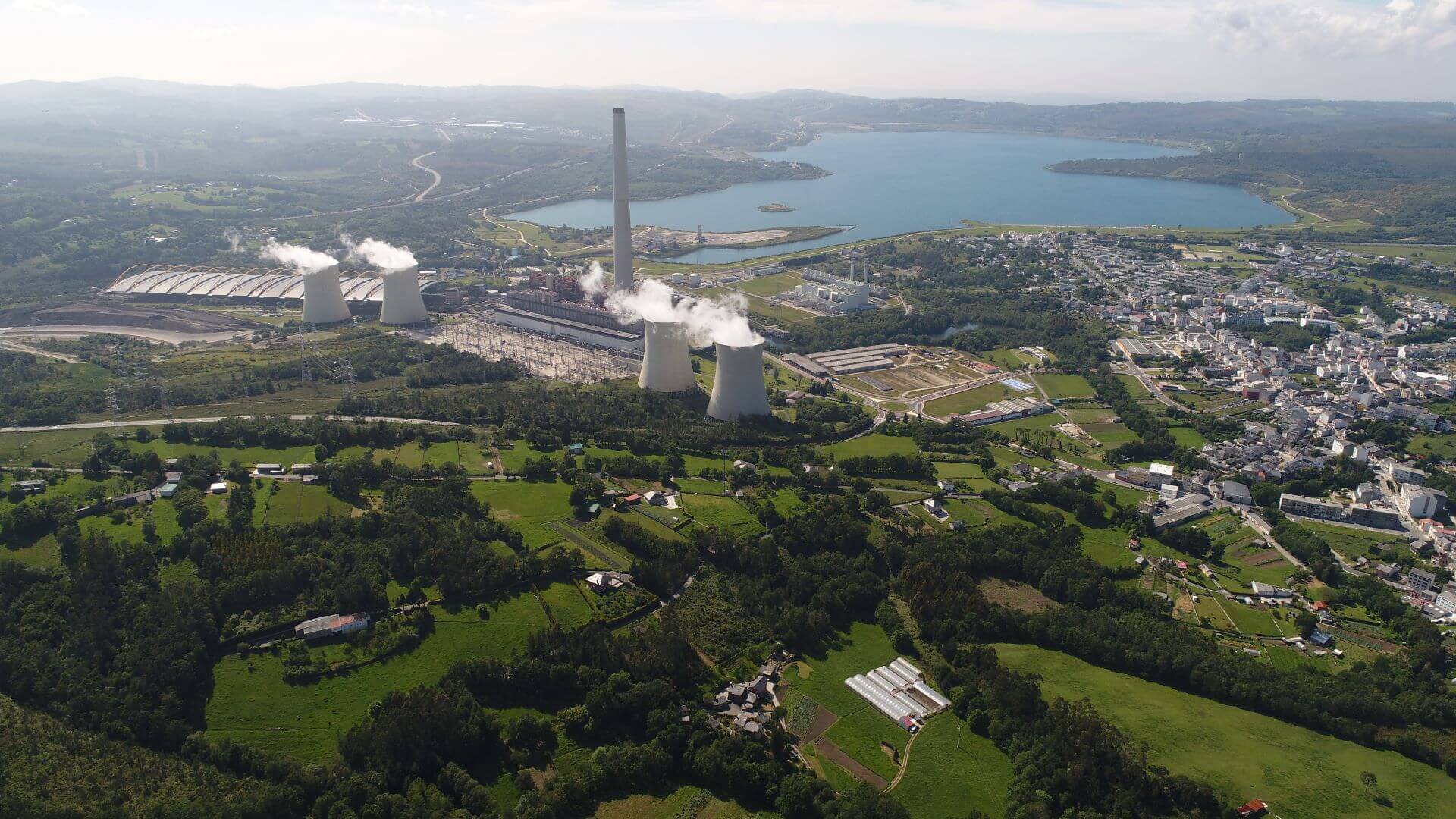 Aerial view of power plant, with lake in the background