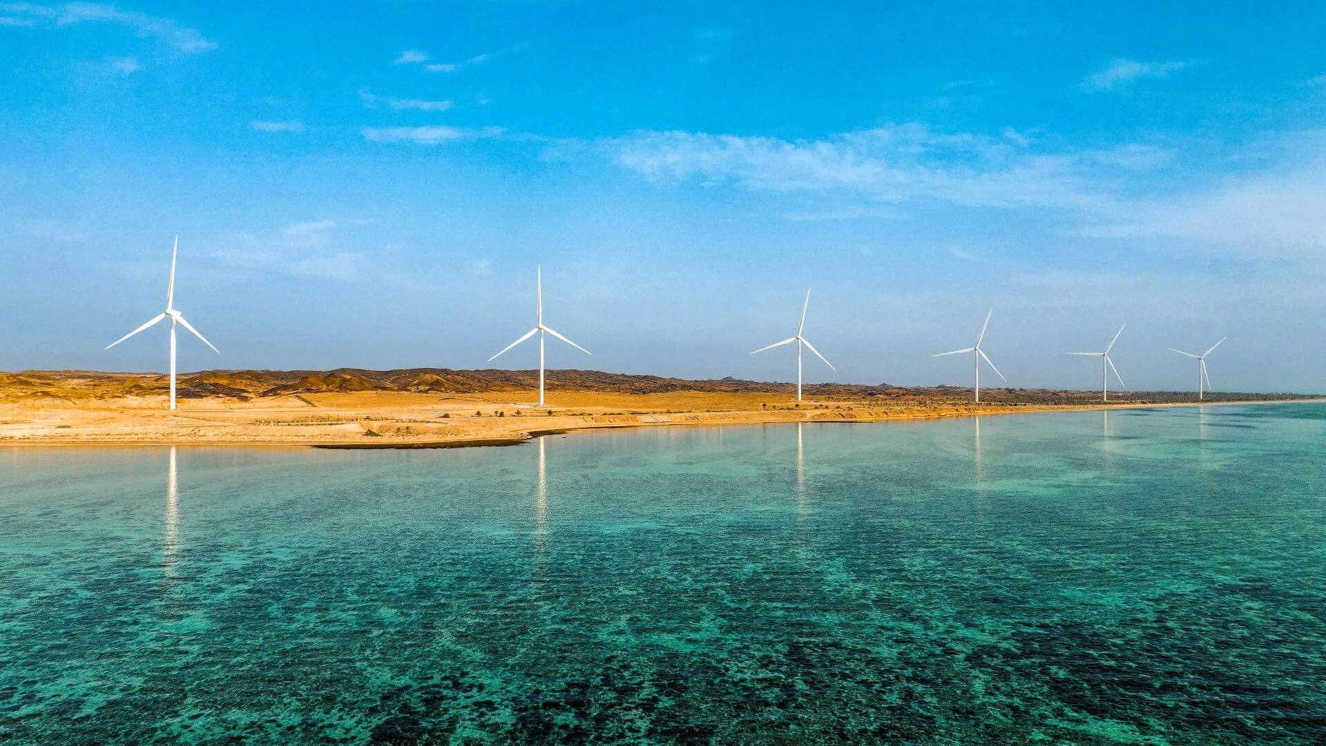 Row of onshore wind turbines along coast line of Delma Island