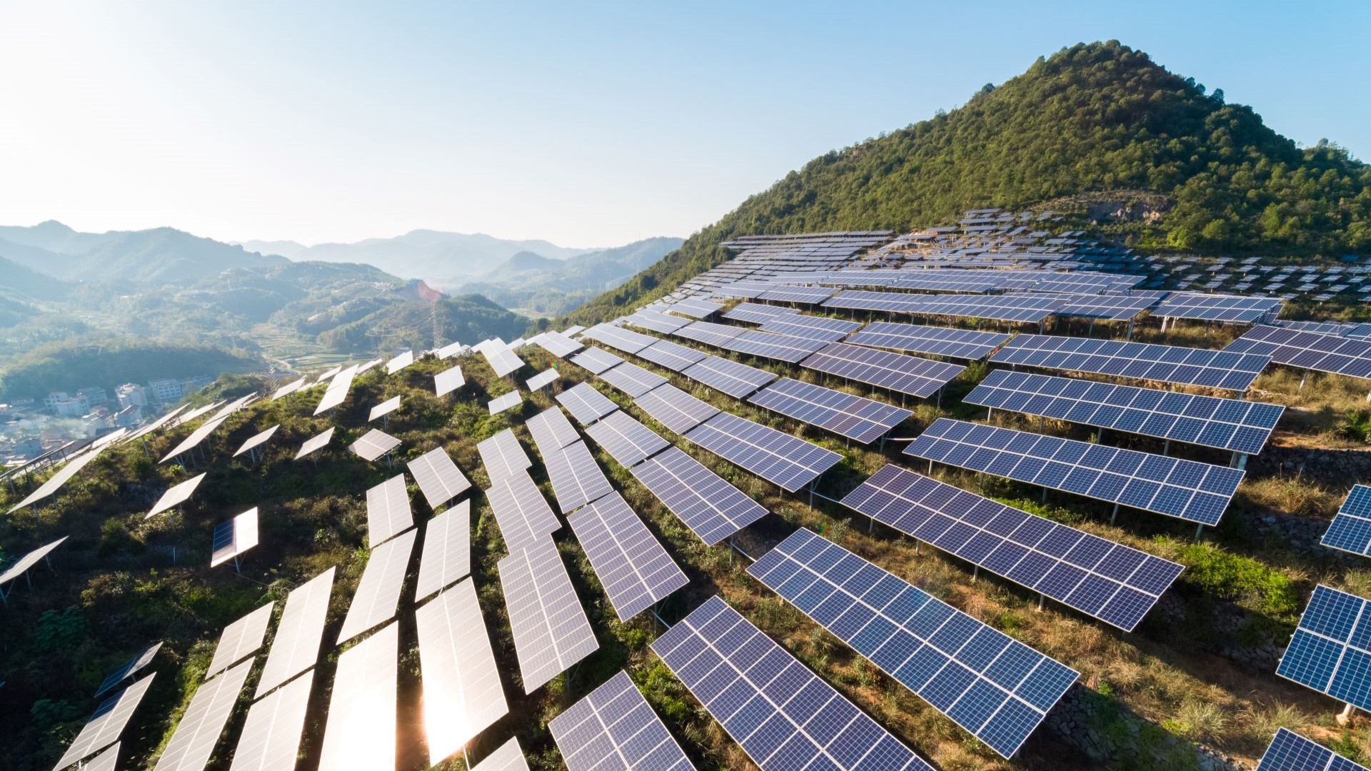Solar panels on side of a hill near a town