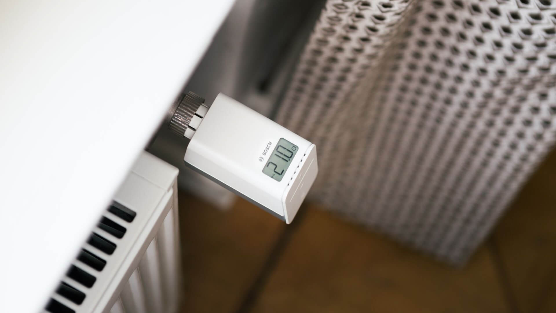 Close up of smart thermostat attached to side of household radiator