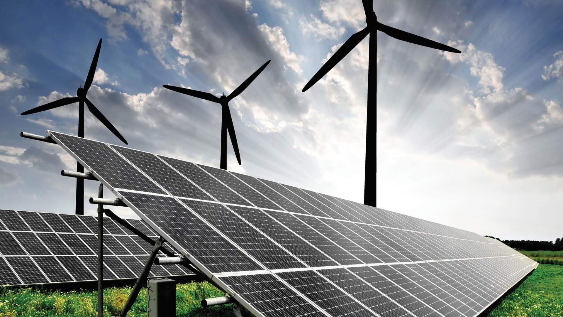 Two rows of solar panels with three wind turbines in the background