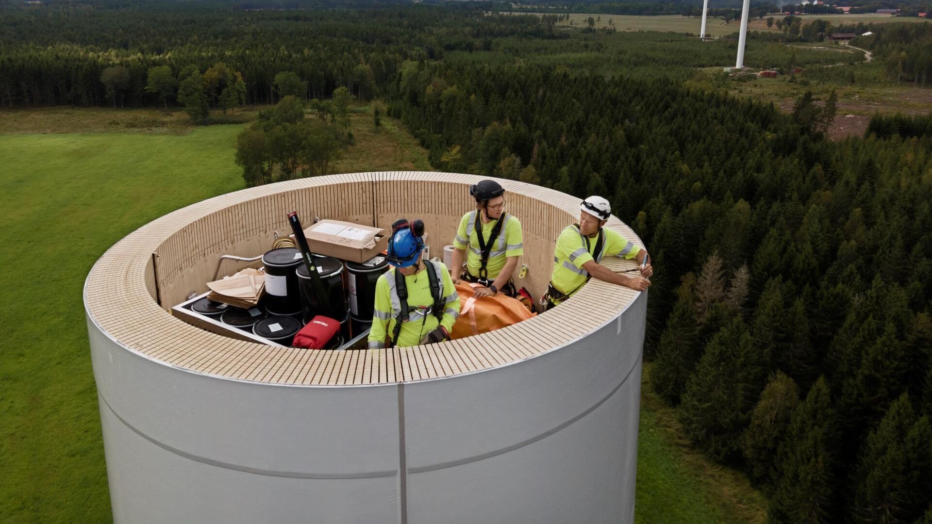 Engineers working on top of the wooden turbine tower