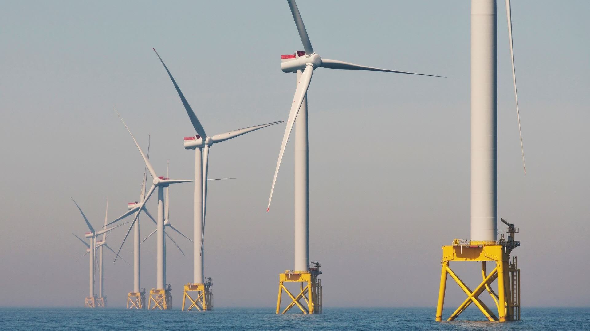 Row of floating wind turbines heading into distance