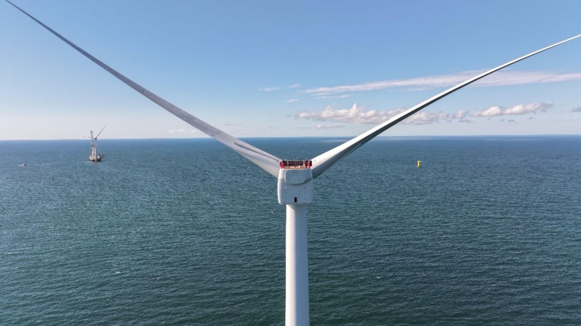 Close up of offshore wind turbine blades with sea behind