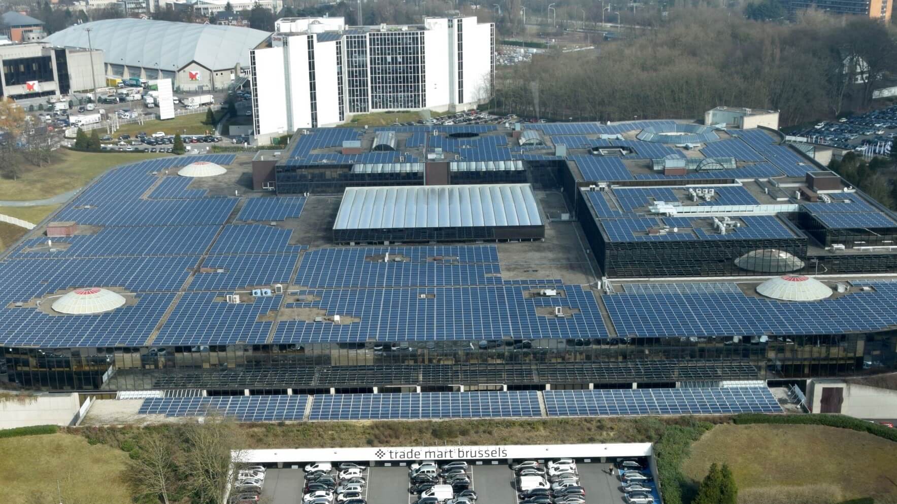 Aerial overview of large building with roof covered in solar panels