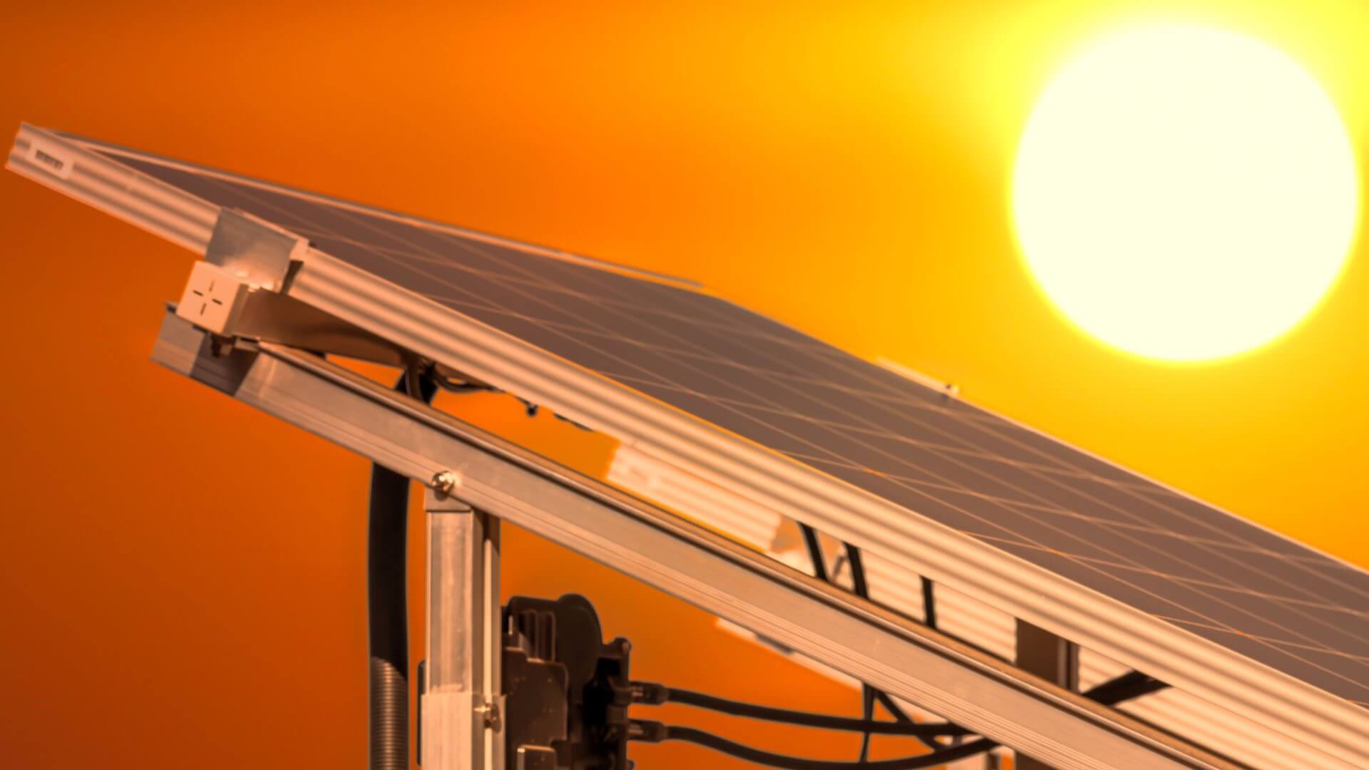 Close up of solar panel with sun in background