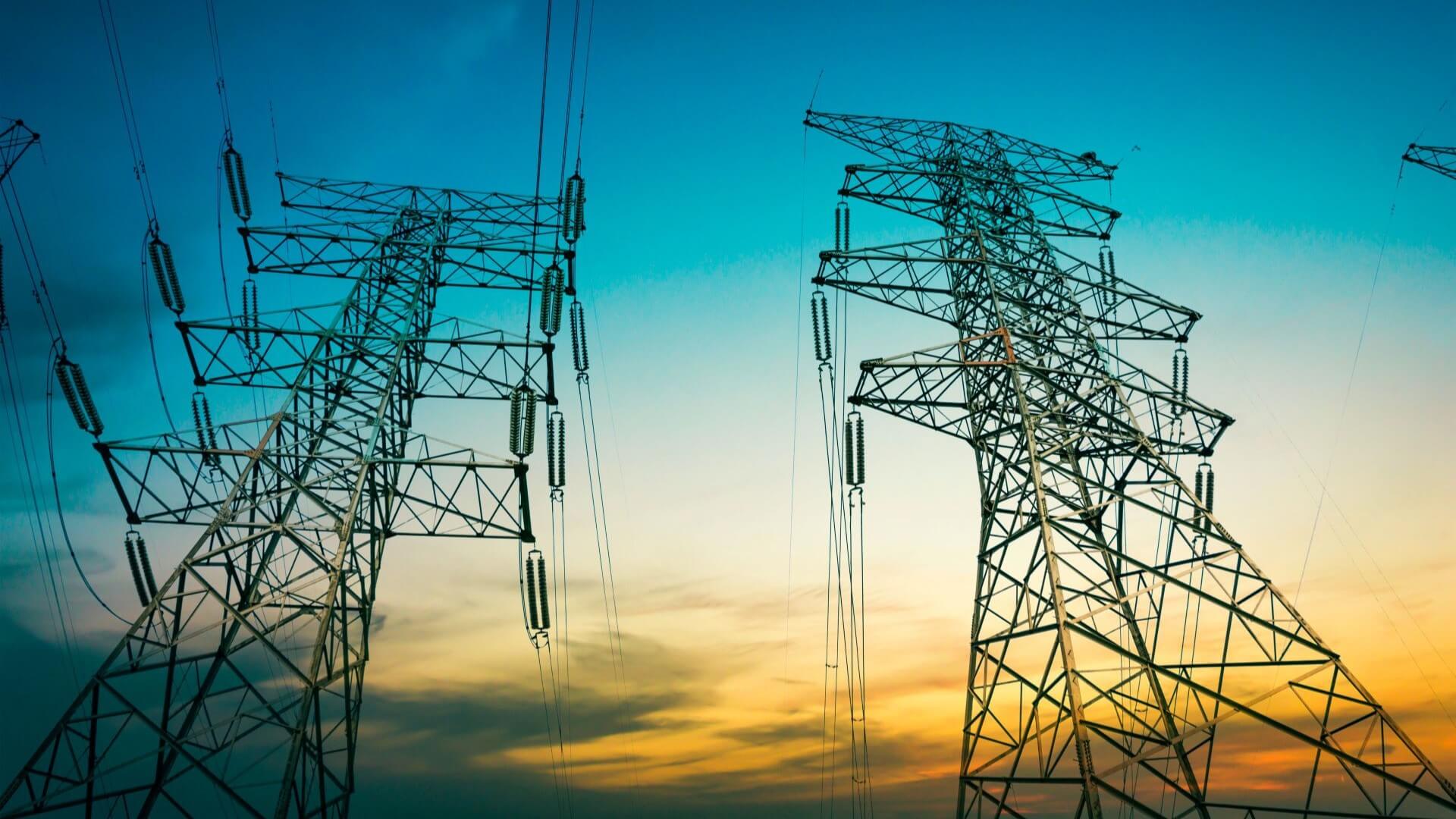 Pylons and transmission lines at sunset