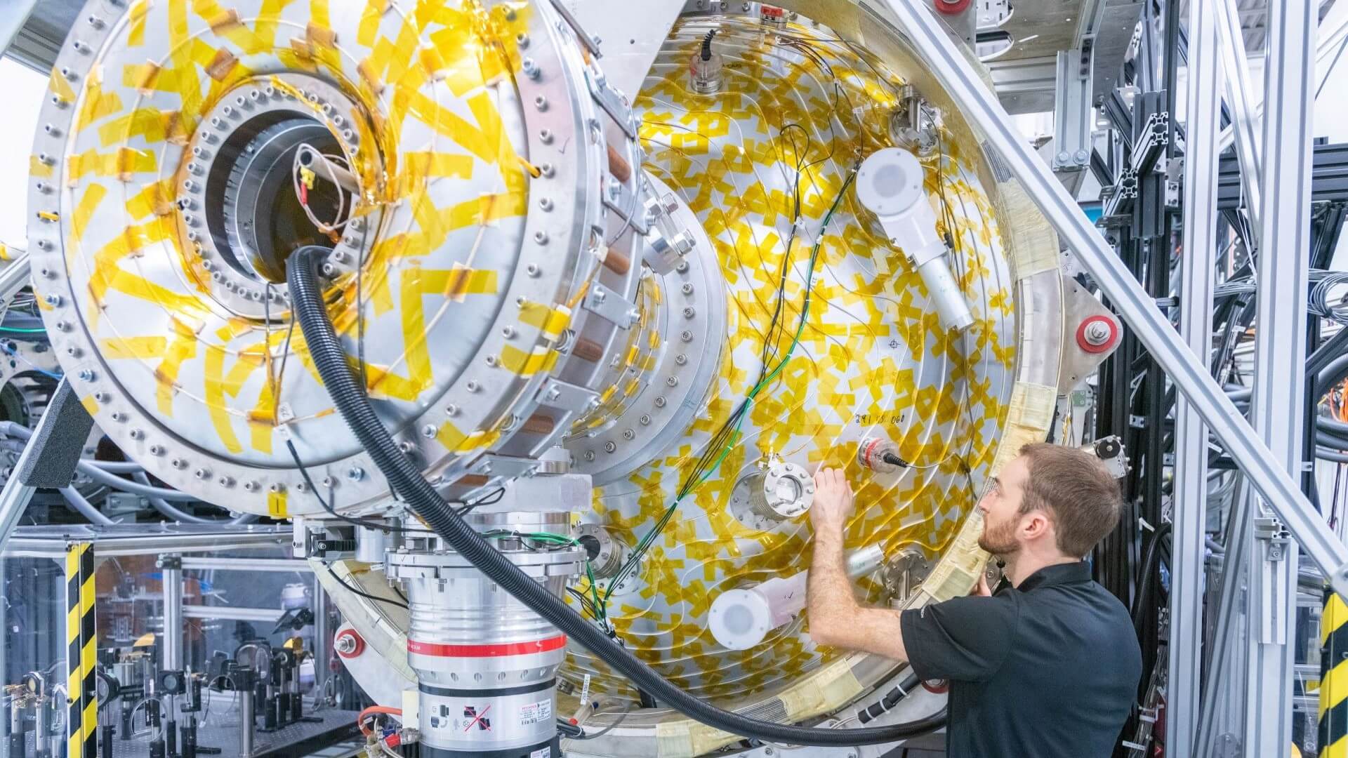 Man working on a section of a cylindrical plasma injector 