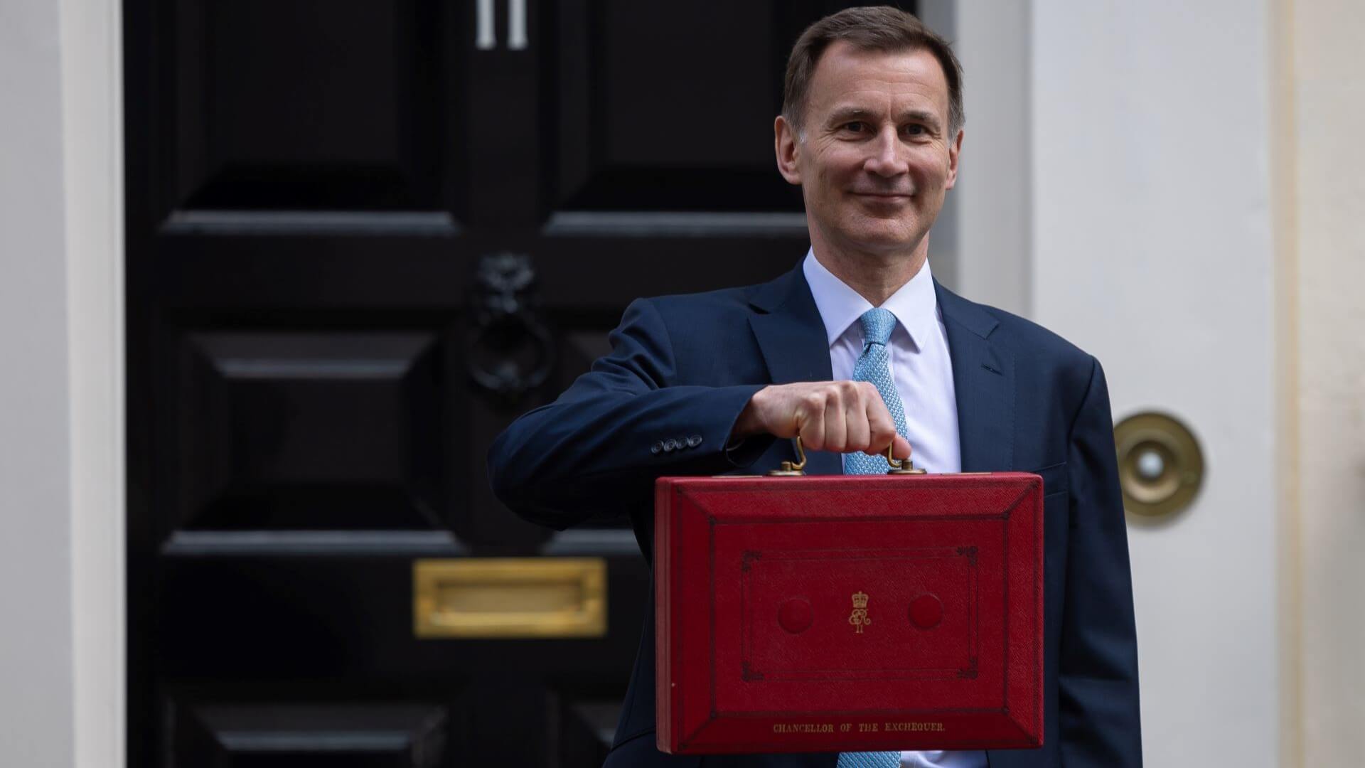 UK Chancellor Jeremy Hunt lifting budget box in Downing Street