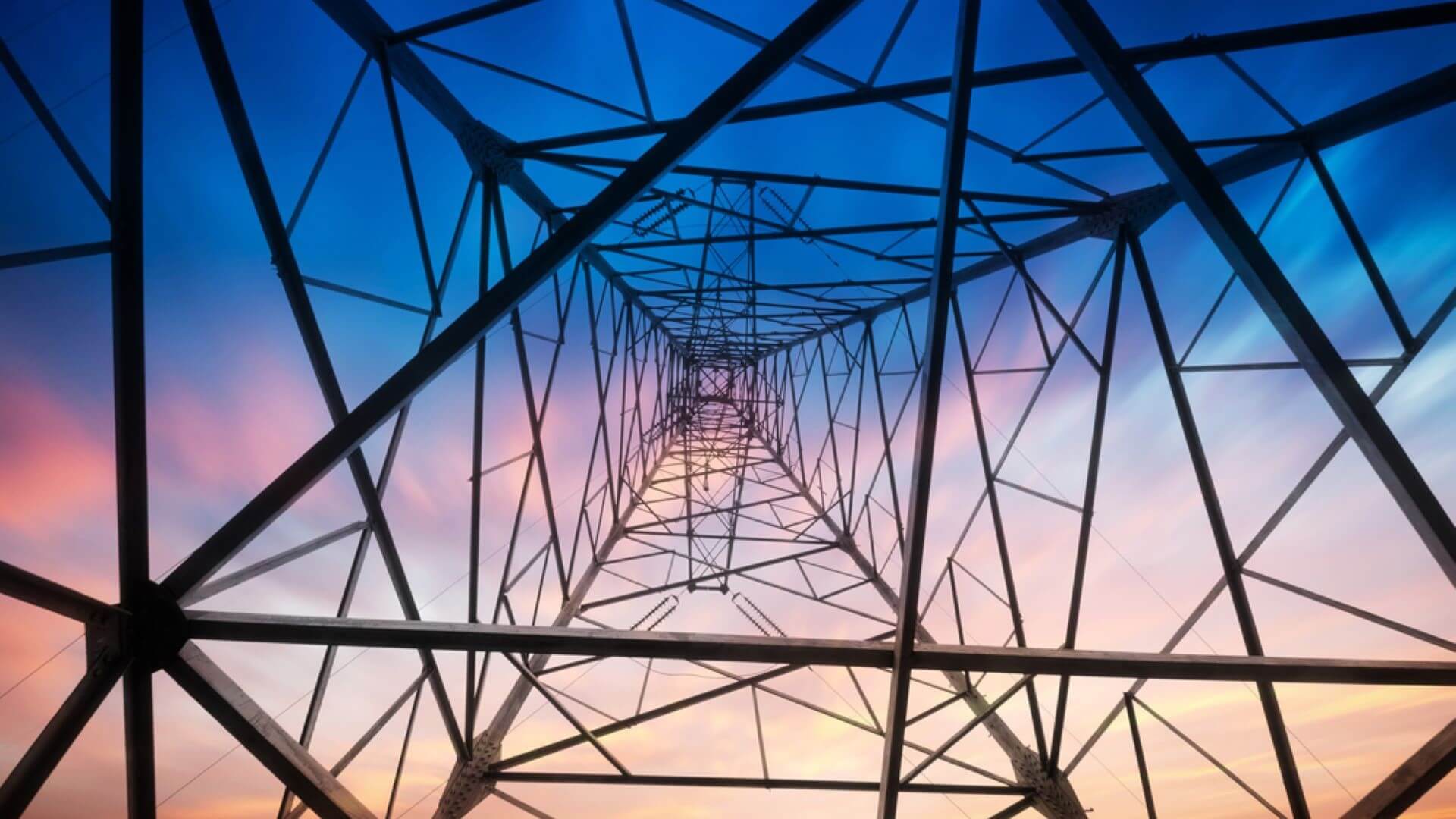 View from centre of base of plyon, looking skywards, with criss-cross structure silhouetted against sunset