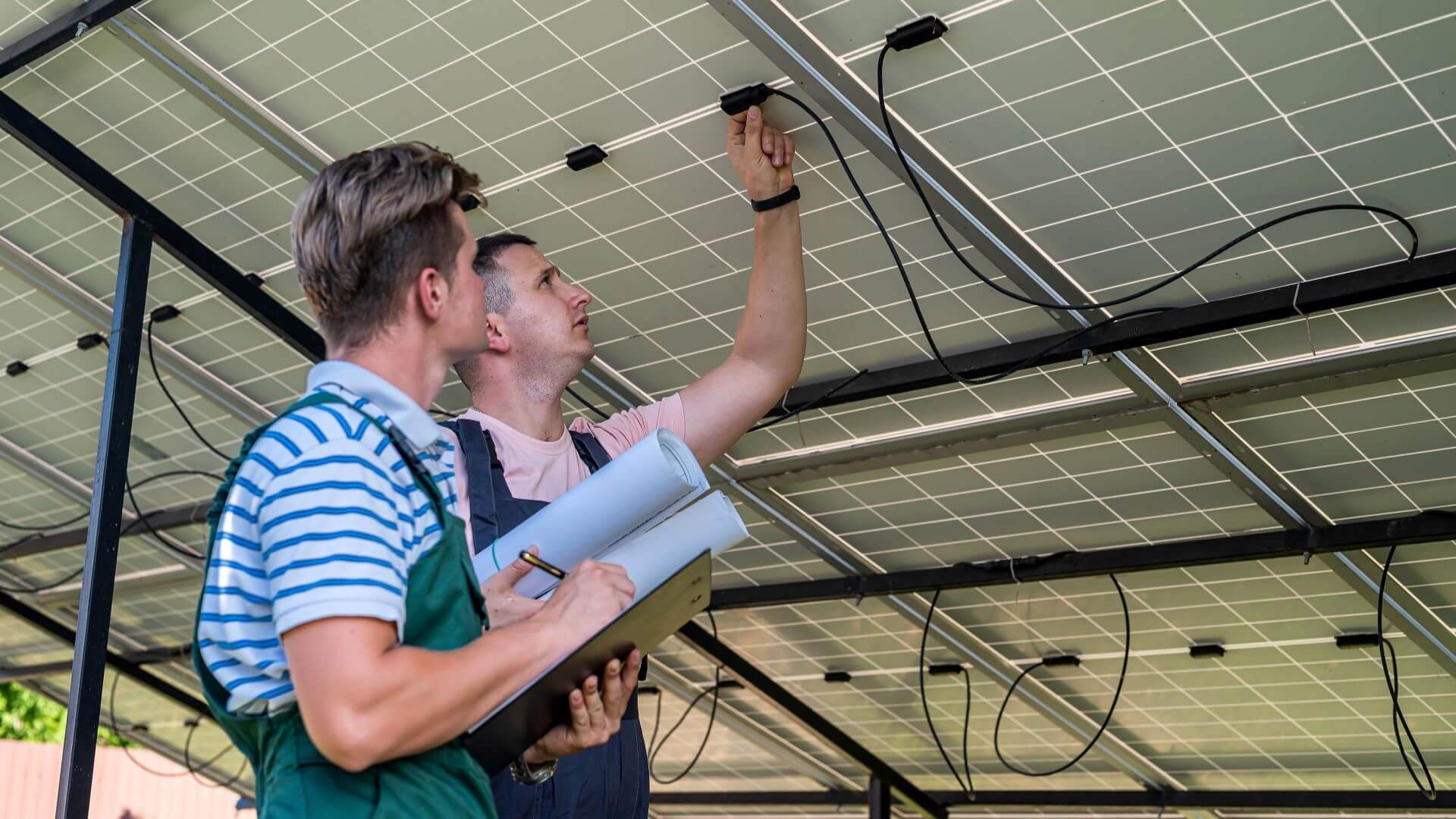 Two engineers working underneath a solar panel 