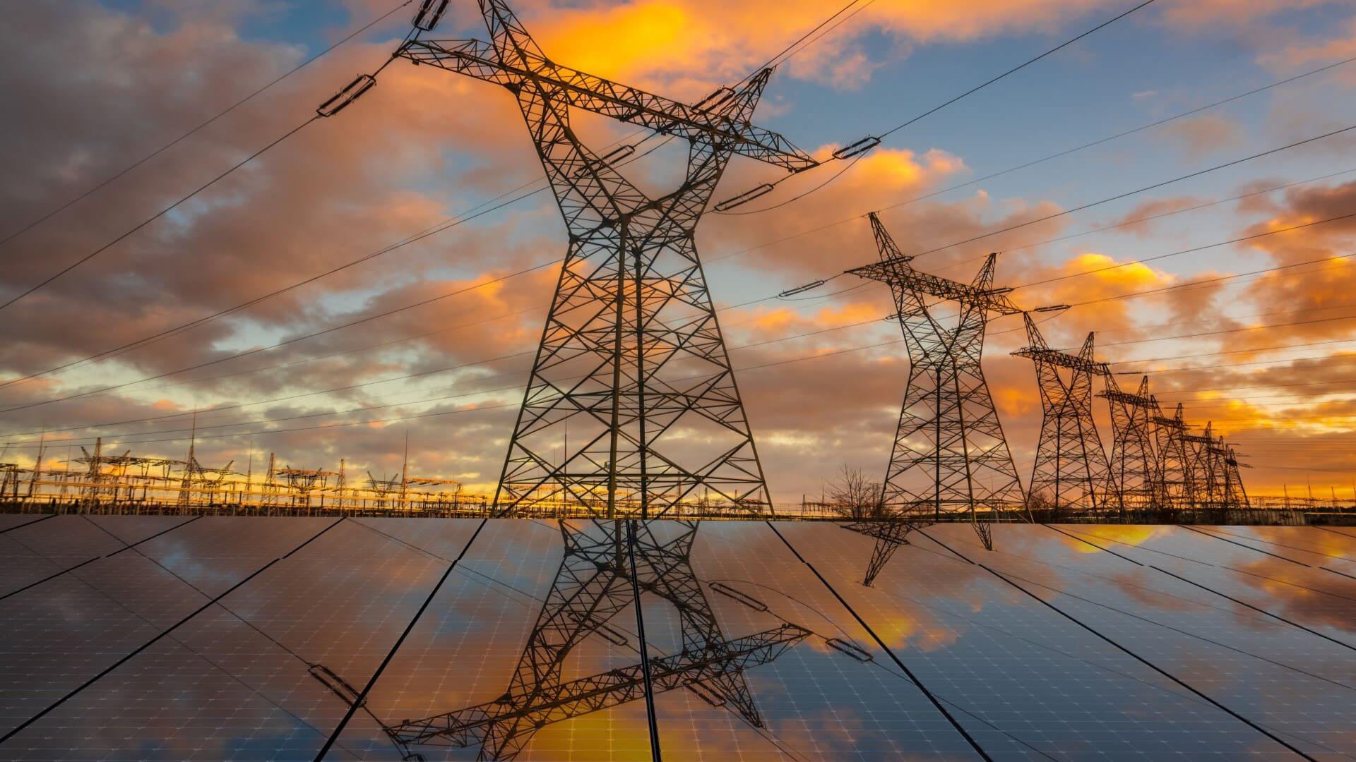 Group of pylons and solar panels at sunset