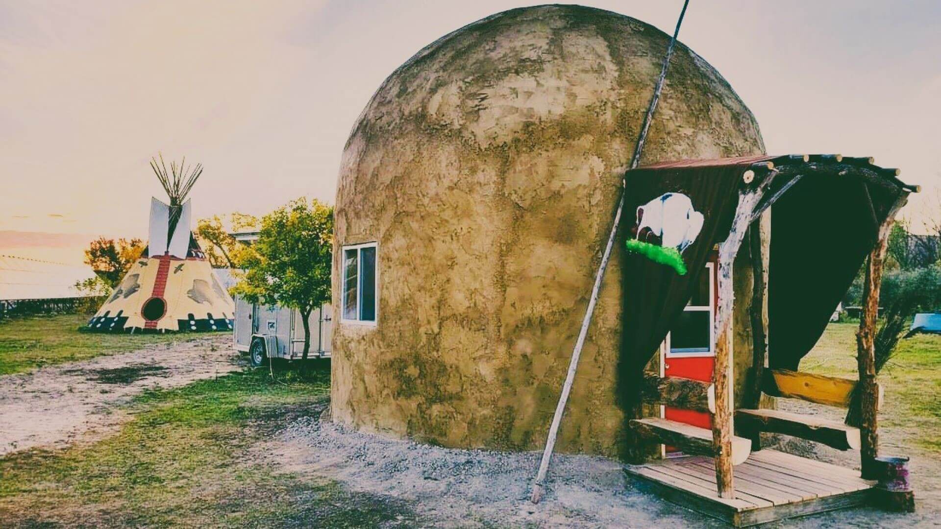 Small dome shaped hut with tiny square wind and rectangular entrance port 
