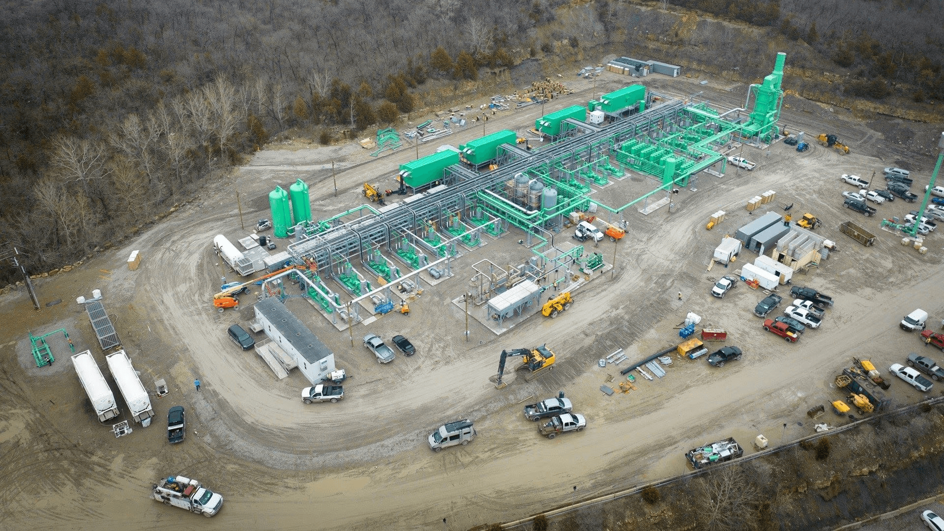 Aerial overview of renewable natural gas plant facilities, with various vehicles clustered at front of buildings