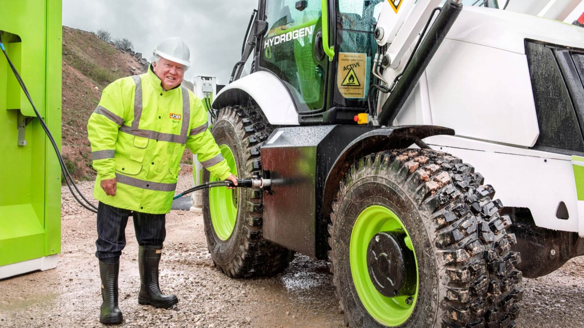 Man in high-viz jacket and hard hat refuelling a large digger truck